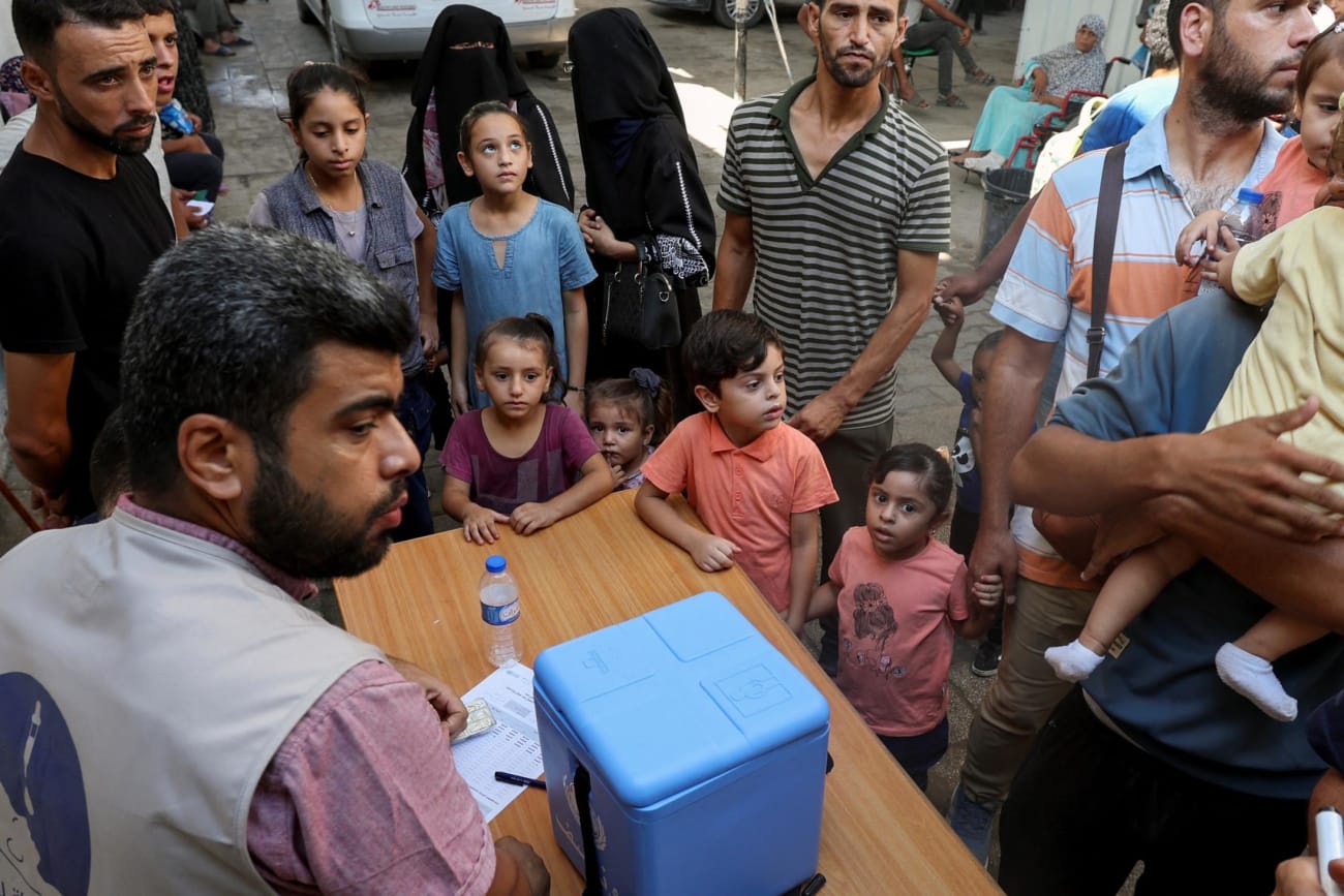 Palestinian children, accompanied by parents, wait to be vaccinated against polio.