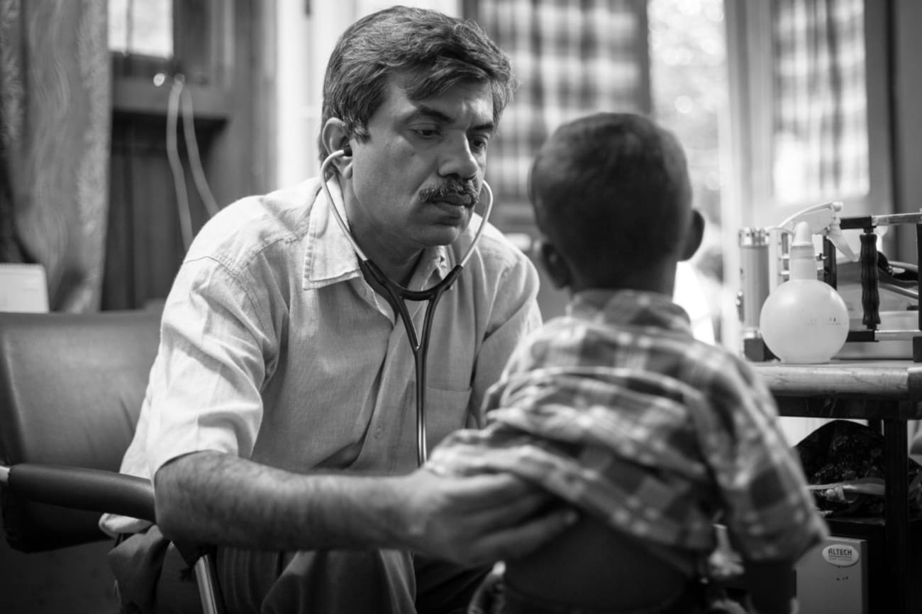 Dr. Yogesh Jain examines a young boy who has sickle cell disease for pneumonia, located in a remote village clinic that does not have any x-ray facilities, in May 2017 at Jan Swasthya Sahyog community health program