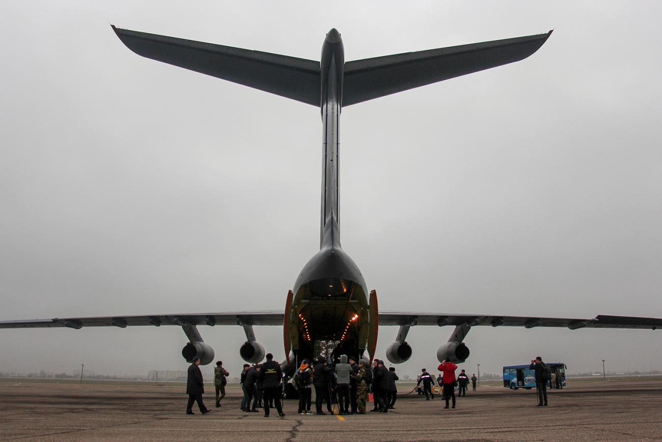 Photo is striking, capturing the plane from behind, its tail foils high above the heads of the people like a whale's tail. 