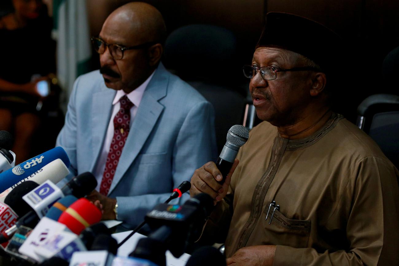The picture shows the health minister at a press conference speaking into a microphone.