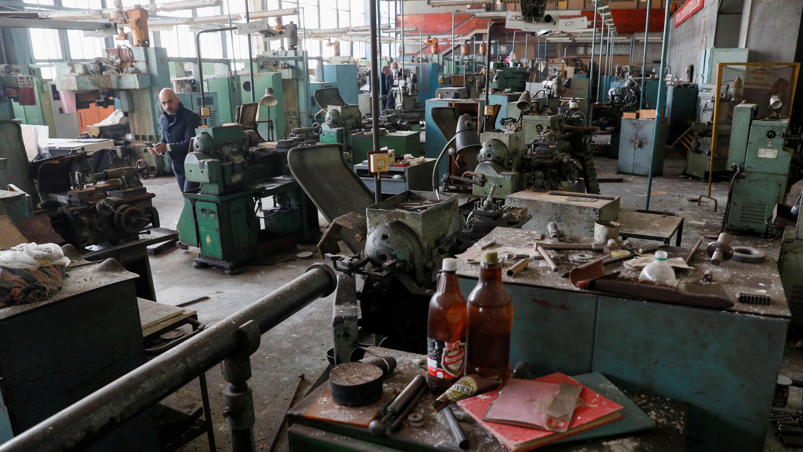 Picture shows the director in an old factory that looks mothballed and dust-covered.