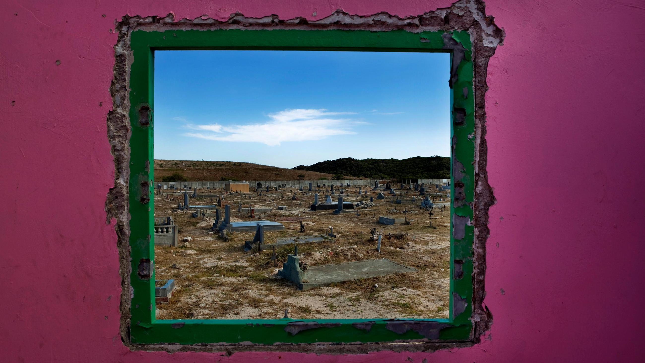 Picture shows a graveyard seen through an open window.