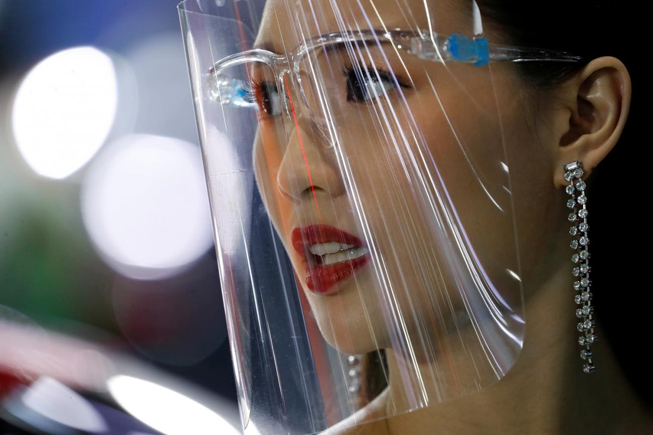 The photo shows a closeup of a woman wearing a face shield.
