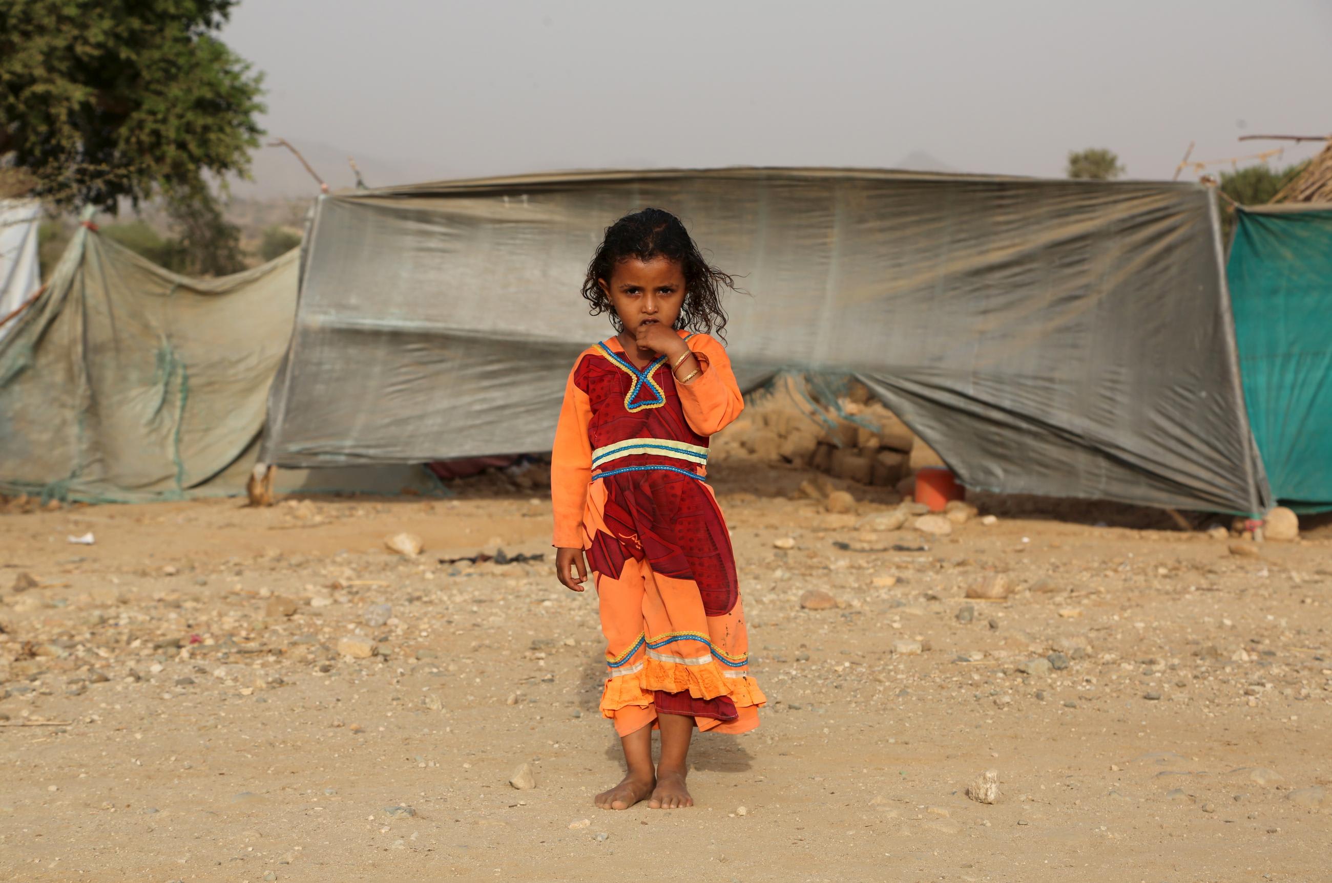 A girl stands outside her family's hut at the Shawqaba camp for people forced to leave their villages due to war in Yemen's northwestern province of Hajjah. Photo taken on March 12, 2016.