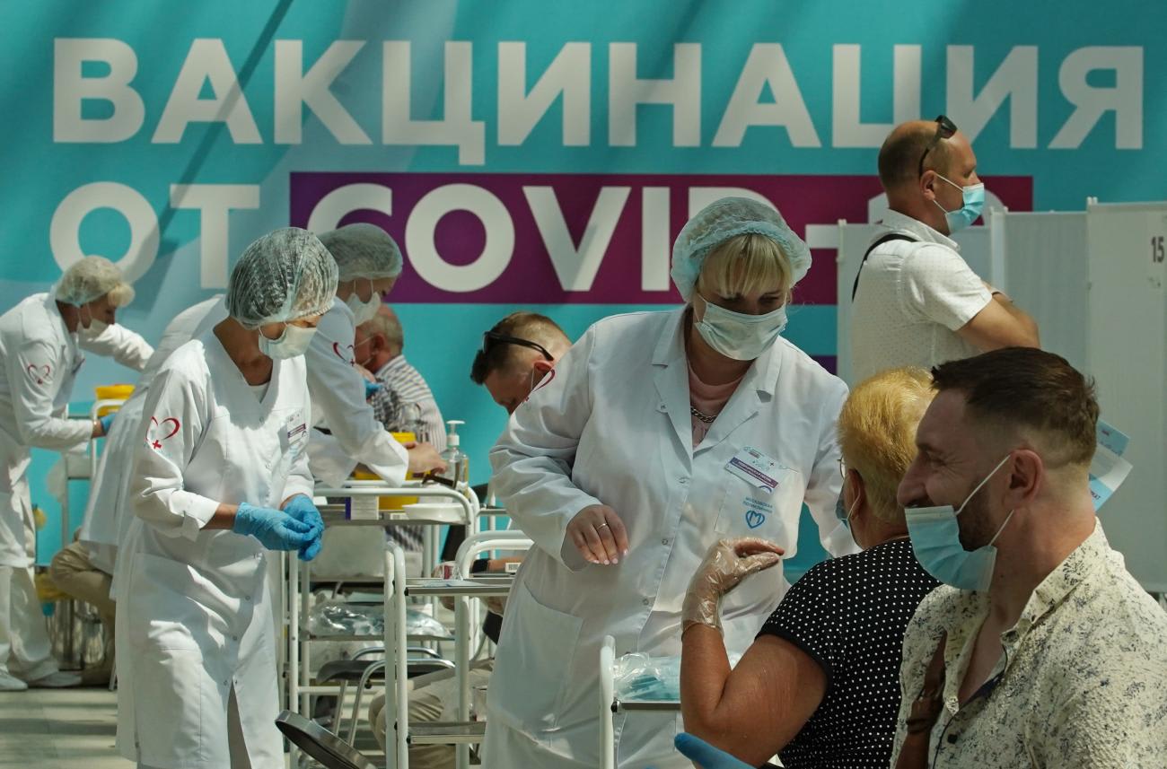 Health care workers wearing PPE give people COVID-19 shots at a vaccination center in Gostiny Dvor in Moscow, Russia on July 6, 2021.