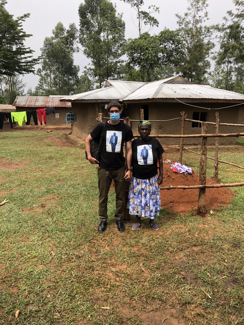 Luqman Mushila Hodgkinson with his mother, Rita Mutola Mushila at his father's grave site, wearing matching shirts with Charles Mushila Shibeka's photo. 