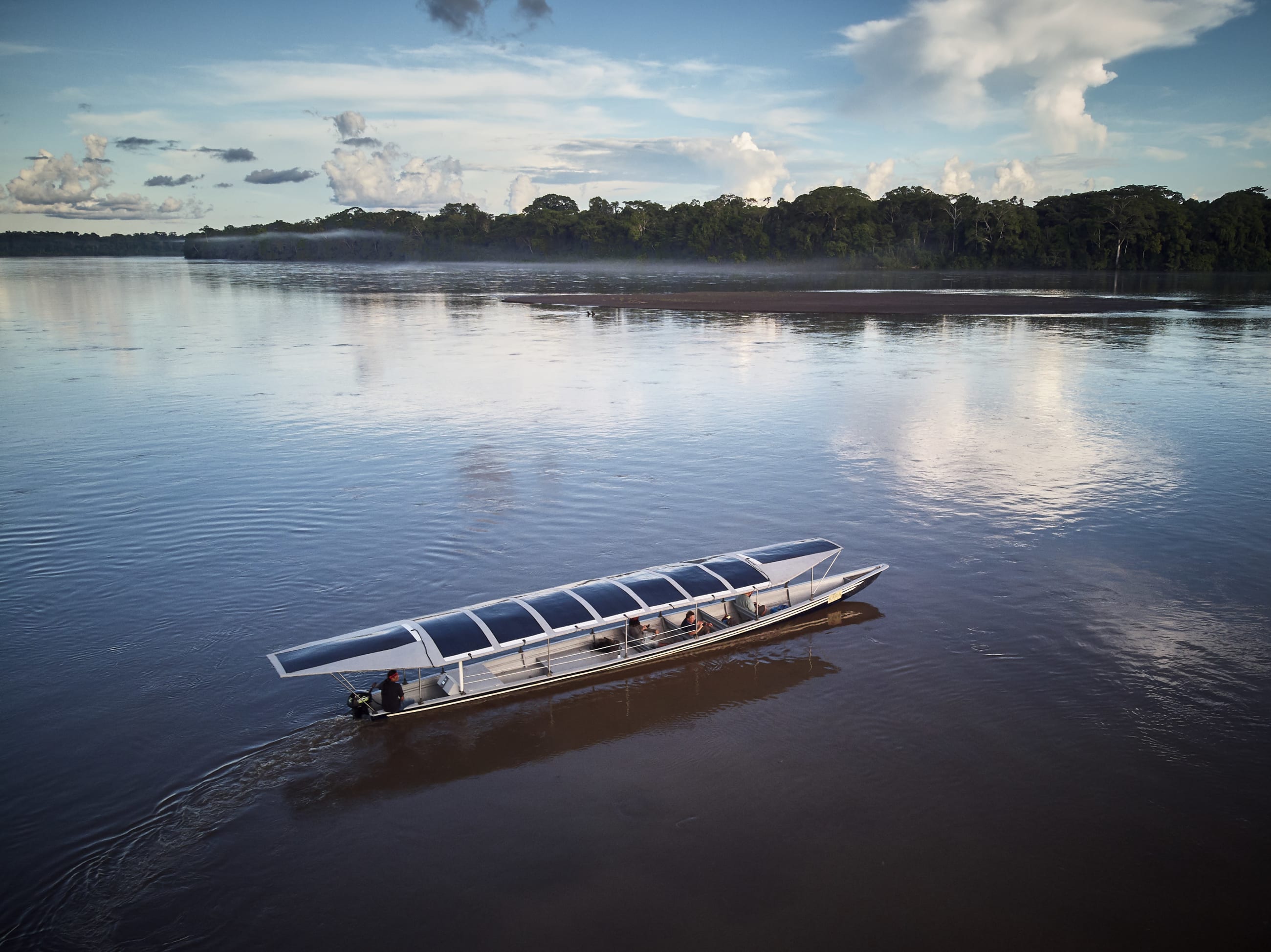 Sunkirum, a solar-powered canoe, sails on the Pastaza River in the Amazon in Ecuador, where the Achuar Indigenous people have lived for thousands of years. 