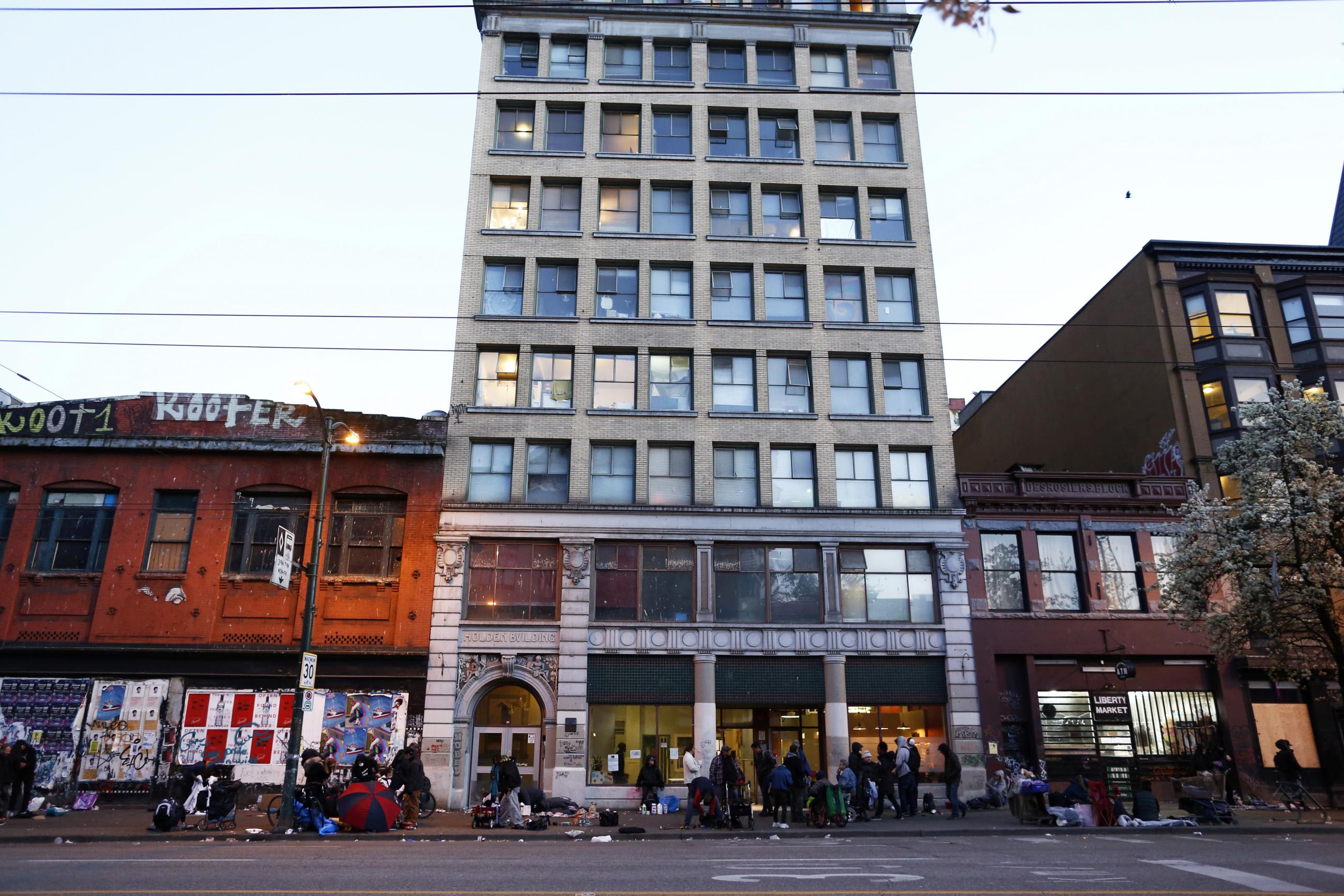 People gather along East Hastings Street as the local health unit has begun prescribing a "safe supply" of narcotic alternatives to combat overdoses in the Downtown Eastside of Vancouver, British Columbia, Canada April 7, 2020. 