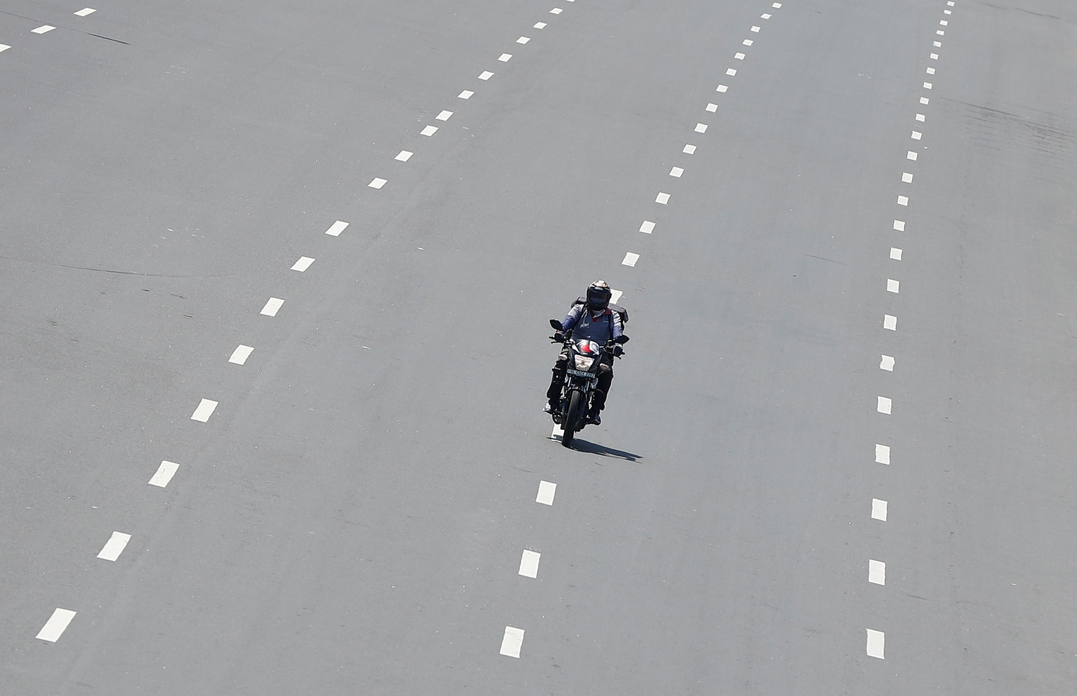 Delivery worker Devender Singh, who works for Licious, an online meat store, rides his bike on a deserted road, in New Delhi, India, on April 6, 2020.