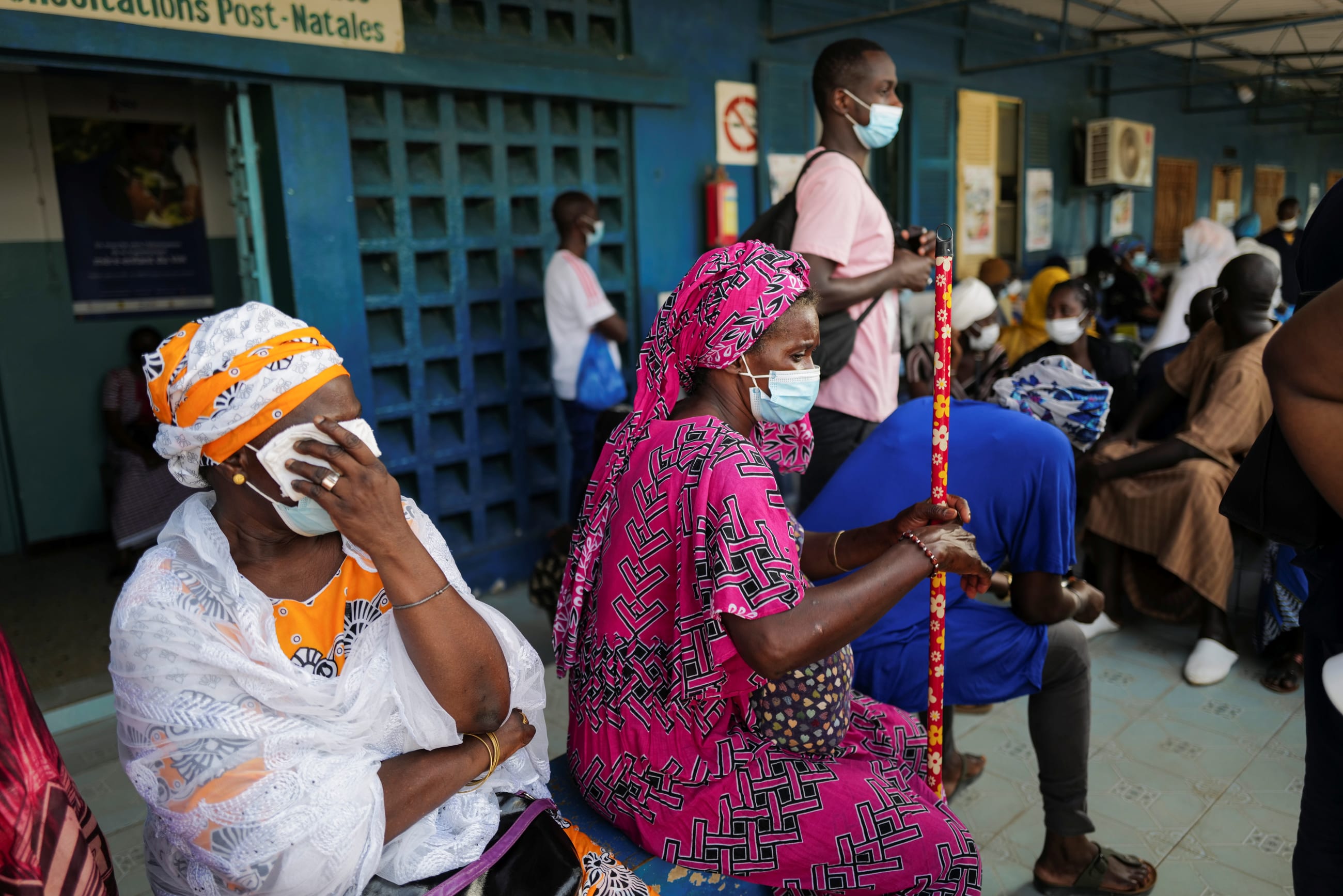 Two women sitting and waiting for a COVID-19 vaccine.