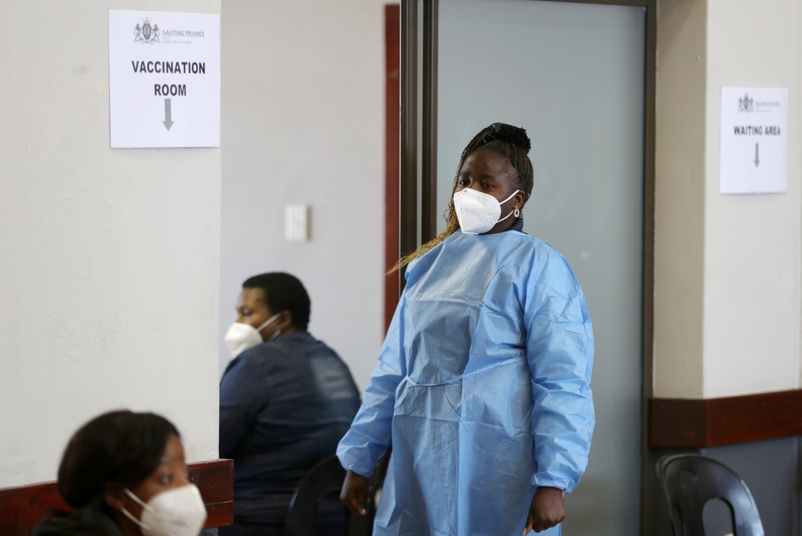 A health worker looks on as she waits to give a dose of the COVID-19 vaccine.
