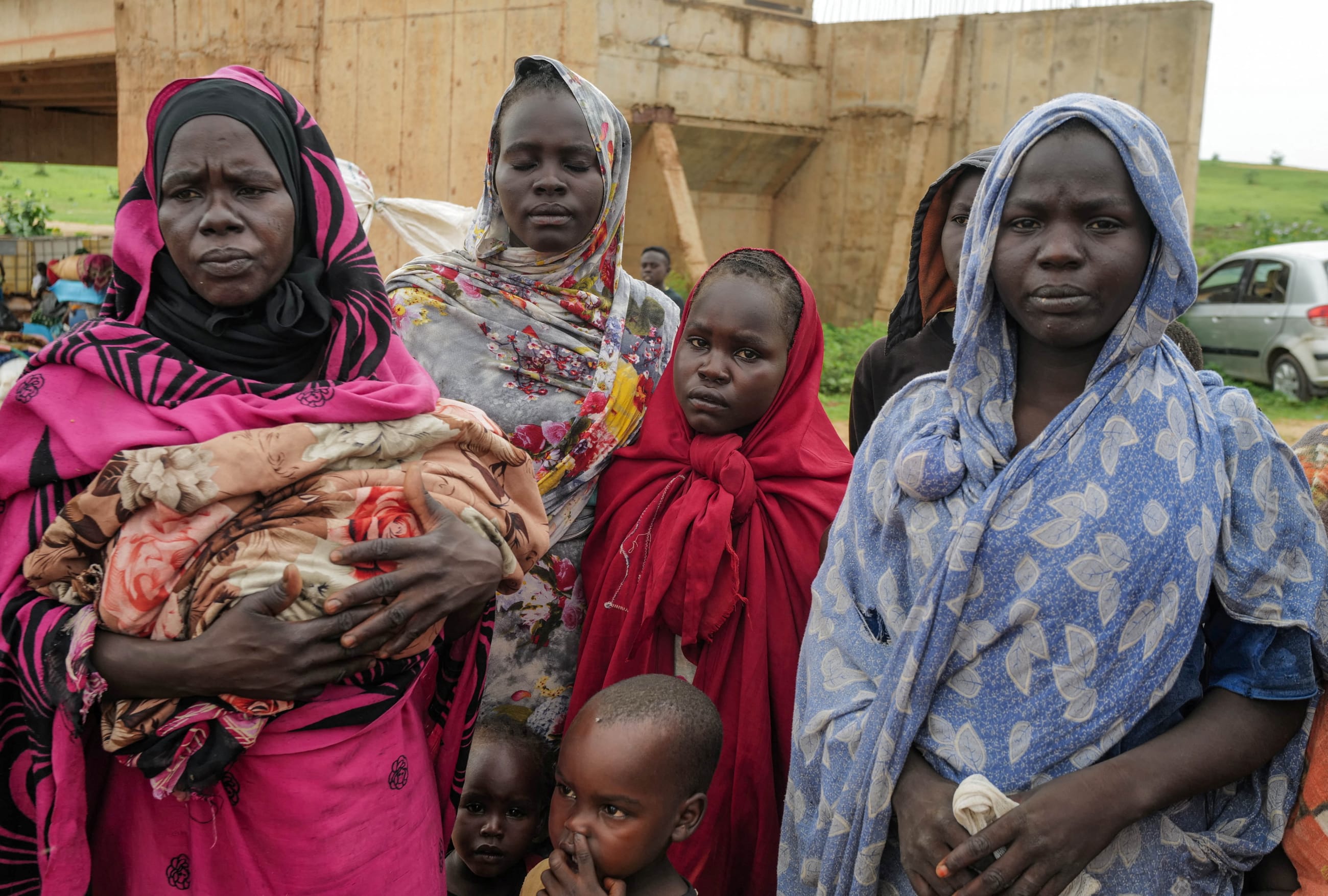Sudanese women, who fled the conflict in Murnei in Sudan's Darfur region, look on while crossing the border between Sudan and Chad.