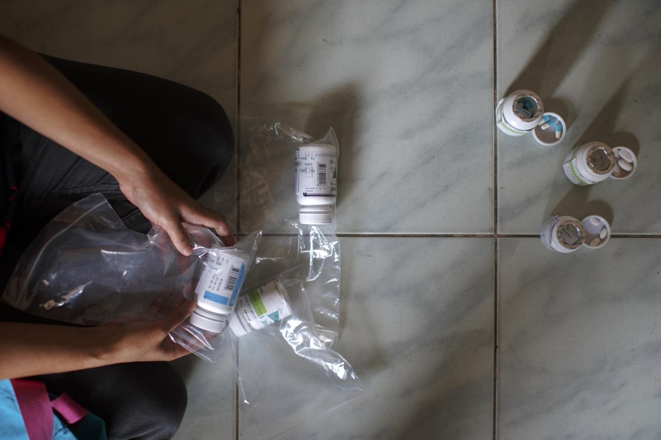 A 39-year-old Burmese migrant living with HIV shows her antiretroviral drugs to a journalist during an interview.