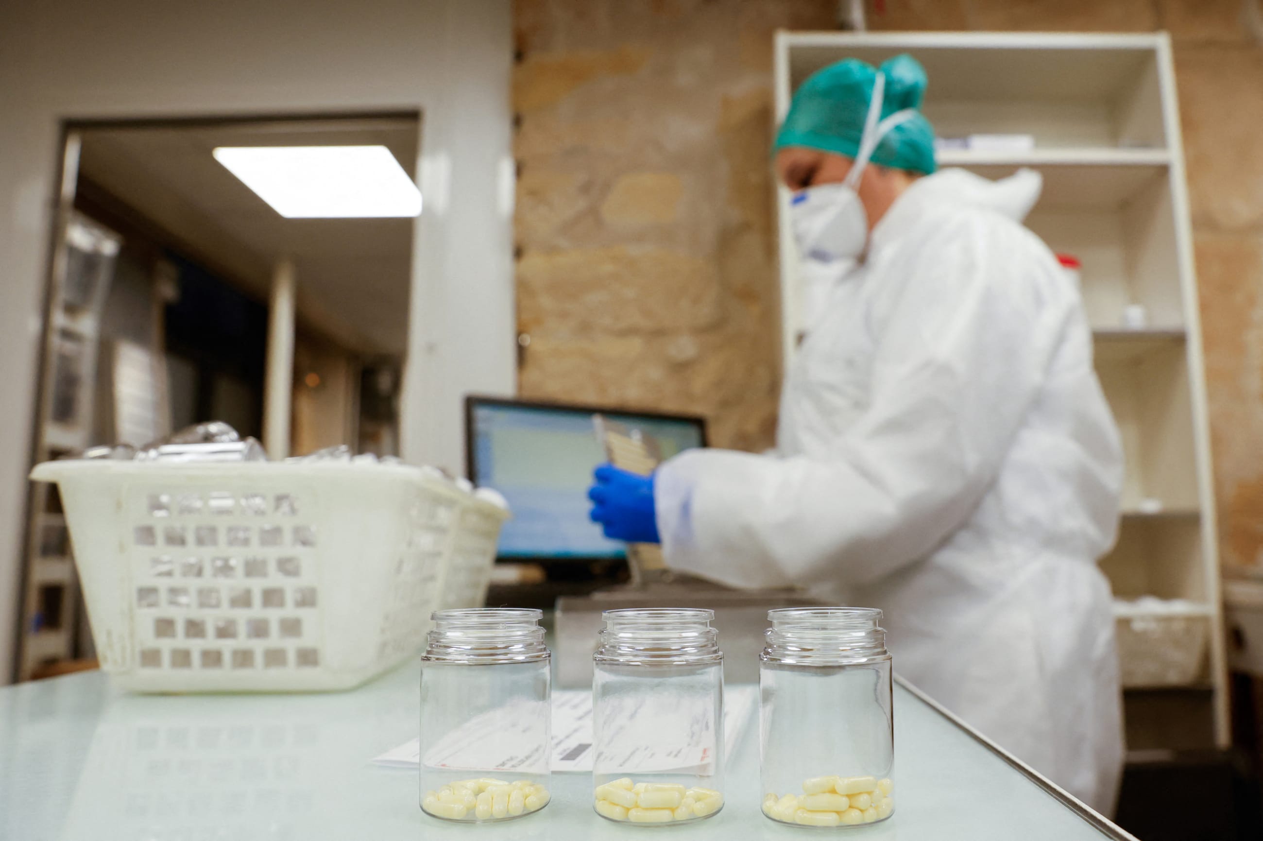 A person works packaging capsules of amoxicillin at the Delpech pharmacy