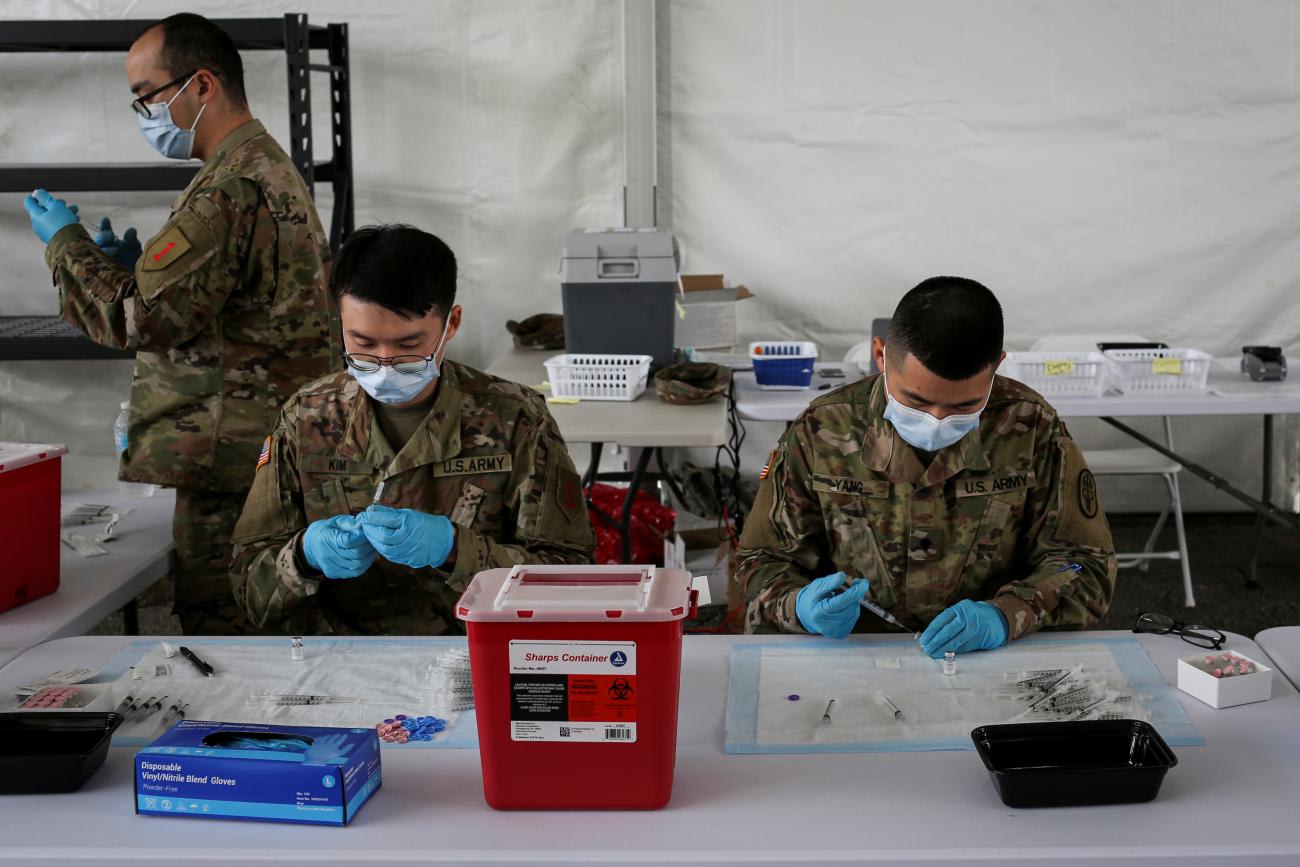 U.S. Army soldiers from the 2nd Armored Brigade Combat Team, 1st Infantry Division, prepare COVID-19 vaccines.