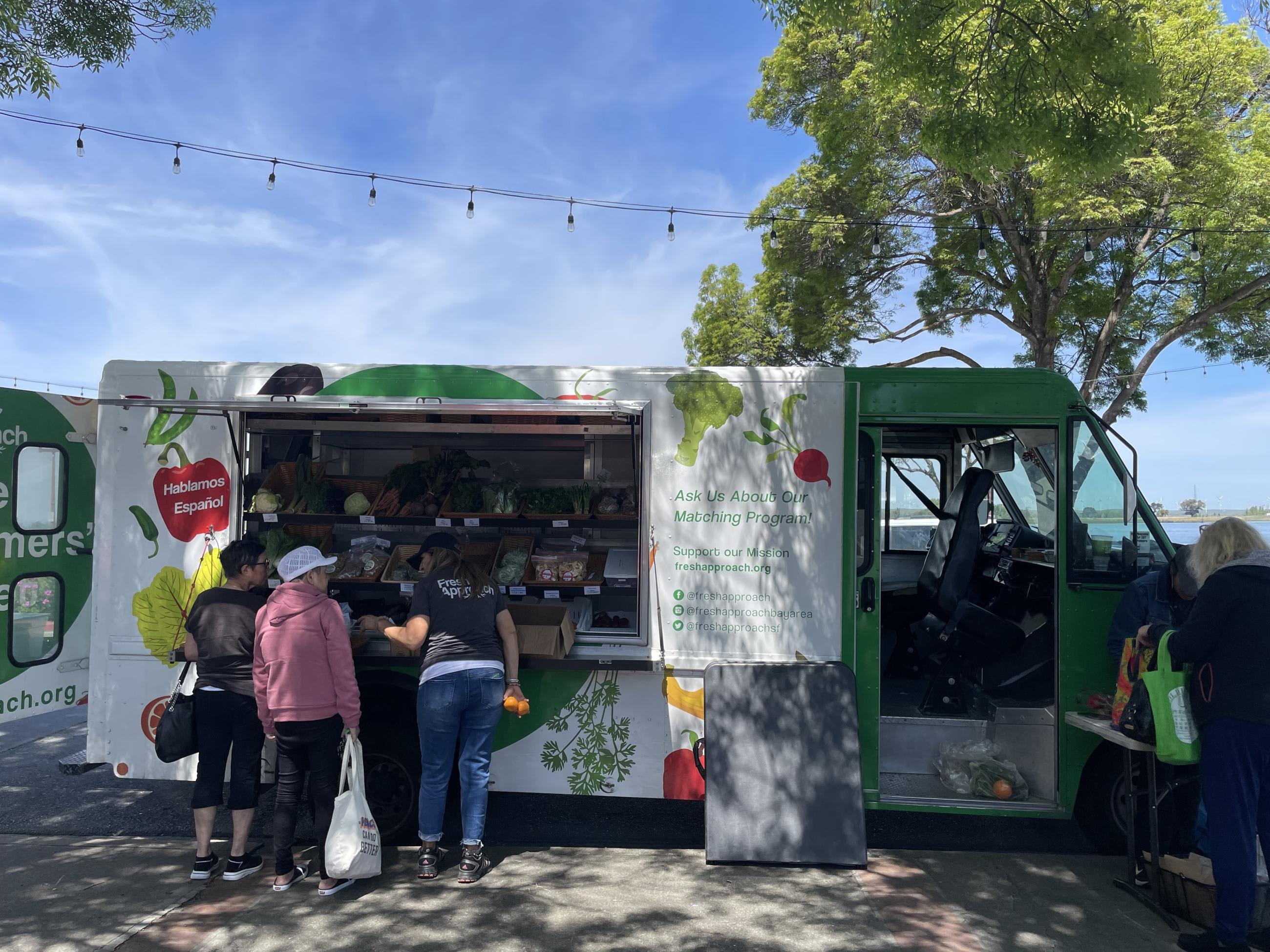 Customers shop at the Fresh Approach mobile farmer's market in Antioch, California. 
