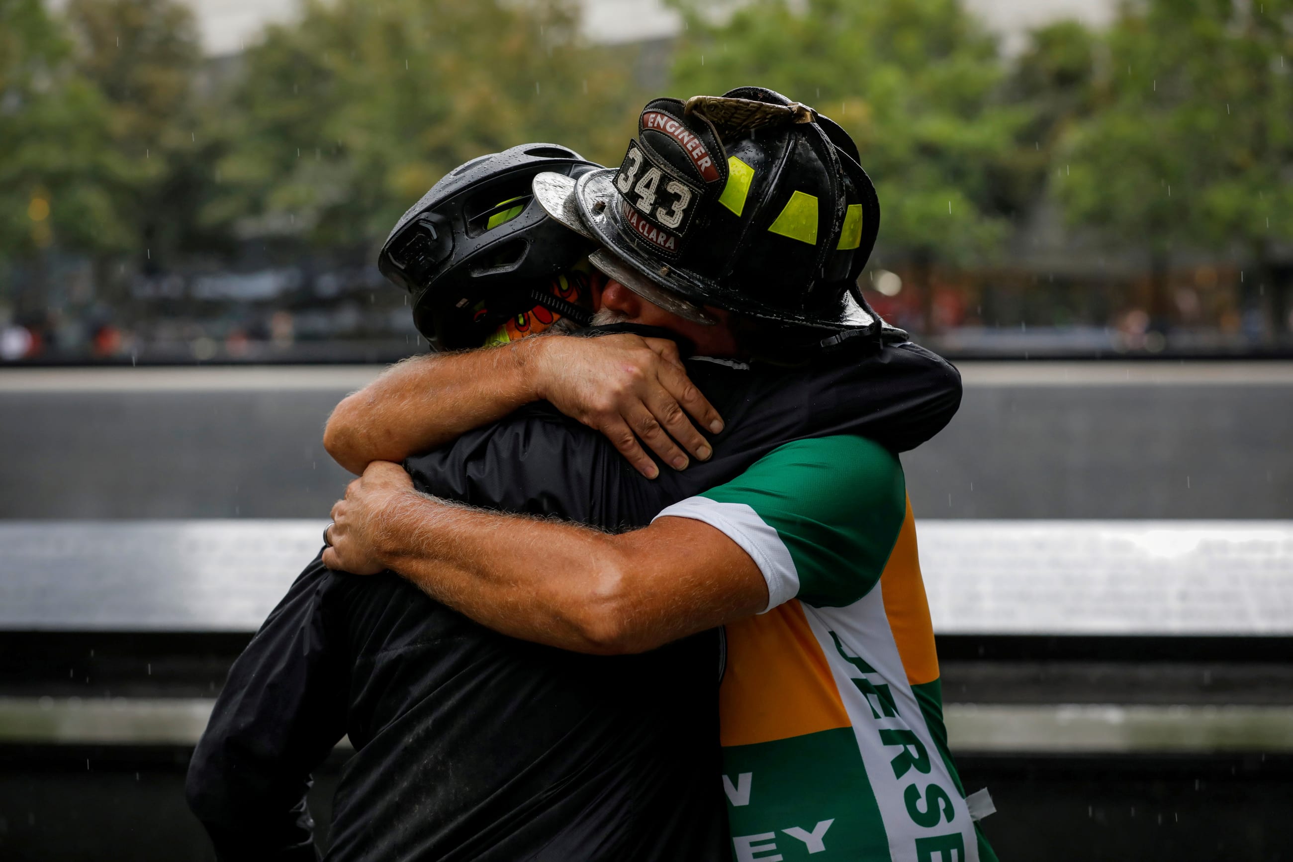 Retired firefighter Darrell Sales of Santa Clara is embraced at the 9/11 Memorial after completing a cross country bicycle ride, named the Bay 2 Brooklyn, to commemorate twentieth anniversary of the September 11 attacks in Manhattan, New York City, September 9, 2021.