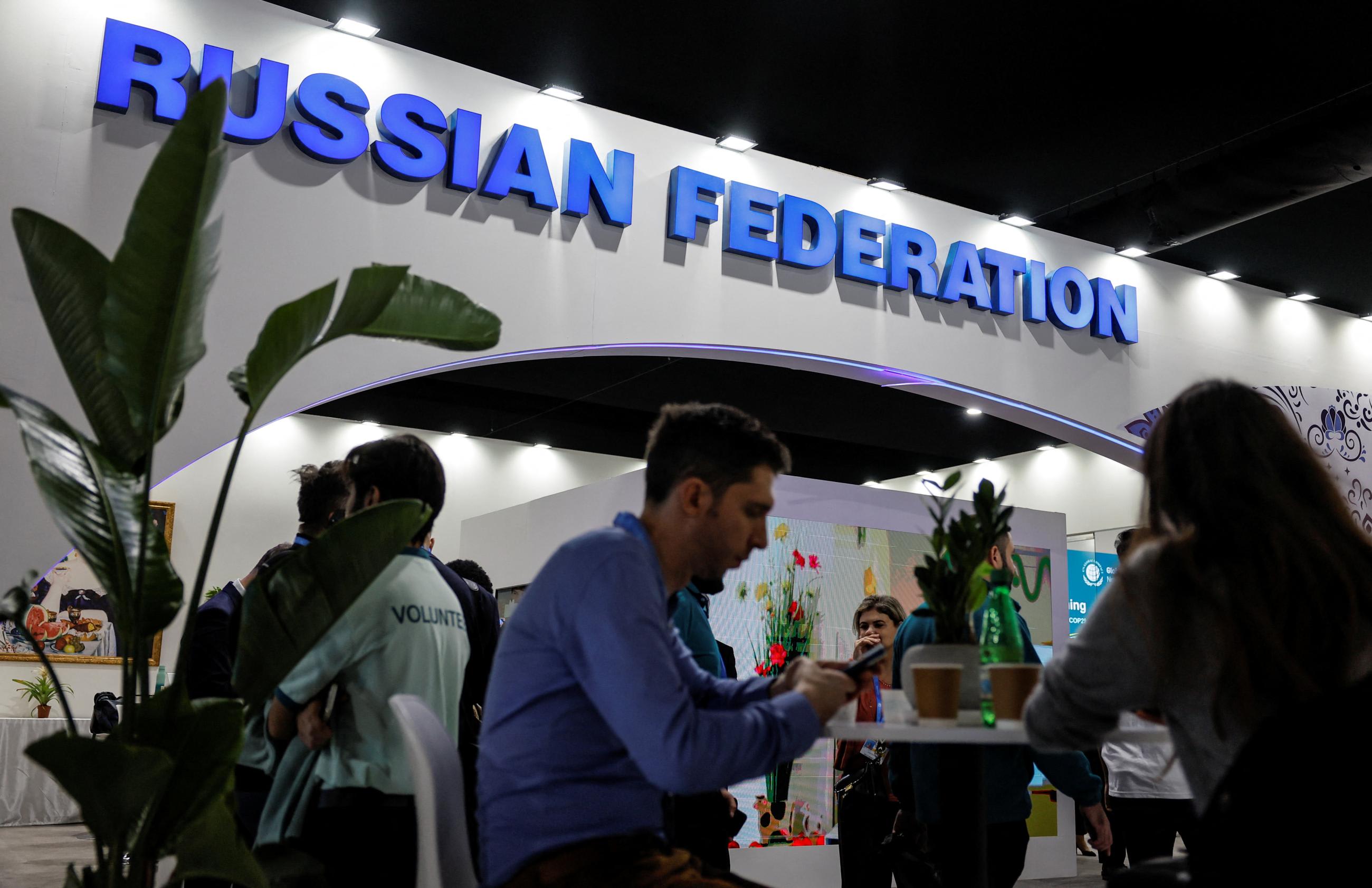 People rest next to the Russia's stand during the United Nations climate change conference COP29 venue.