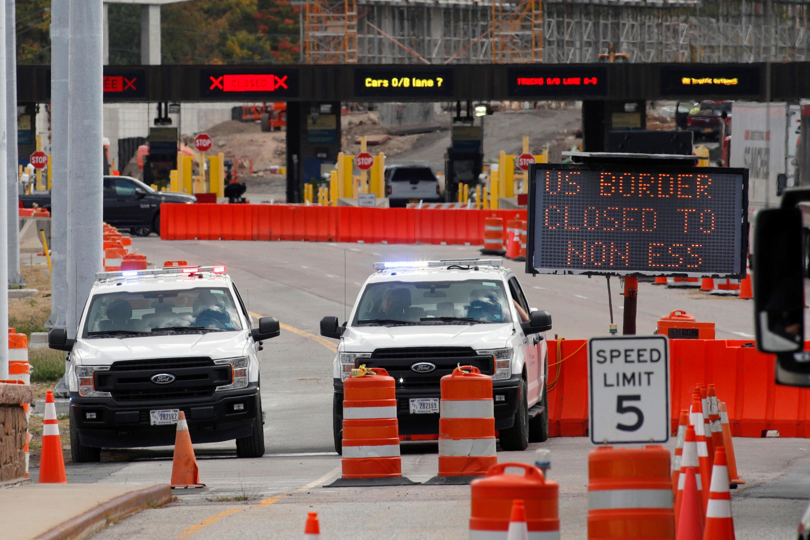U.S. customs vehicles stand near a sign reading that the border is closed to non-essential traffic, at the Canada-United States border crossing, in Lansdowne, Ontario, Canada, on September 28, 2020.