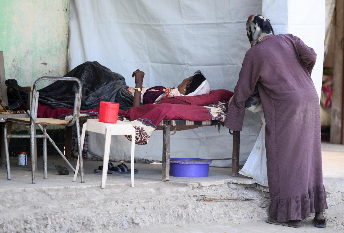 A displaced Sudanese woman rests on a bed at "Abdallah Nagi" shelter camp, in Port Sudan, Sudan, on April 15, 2025. 