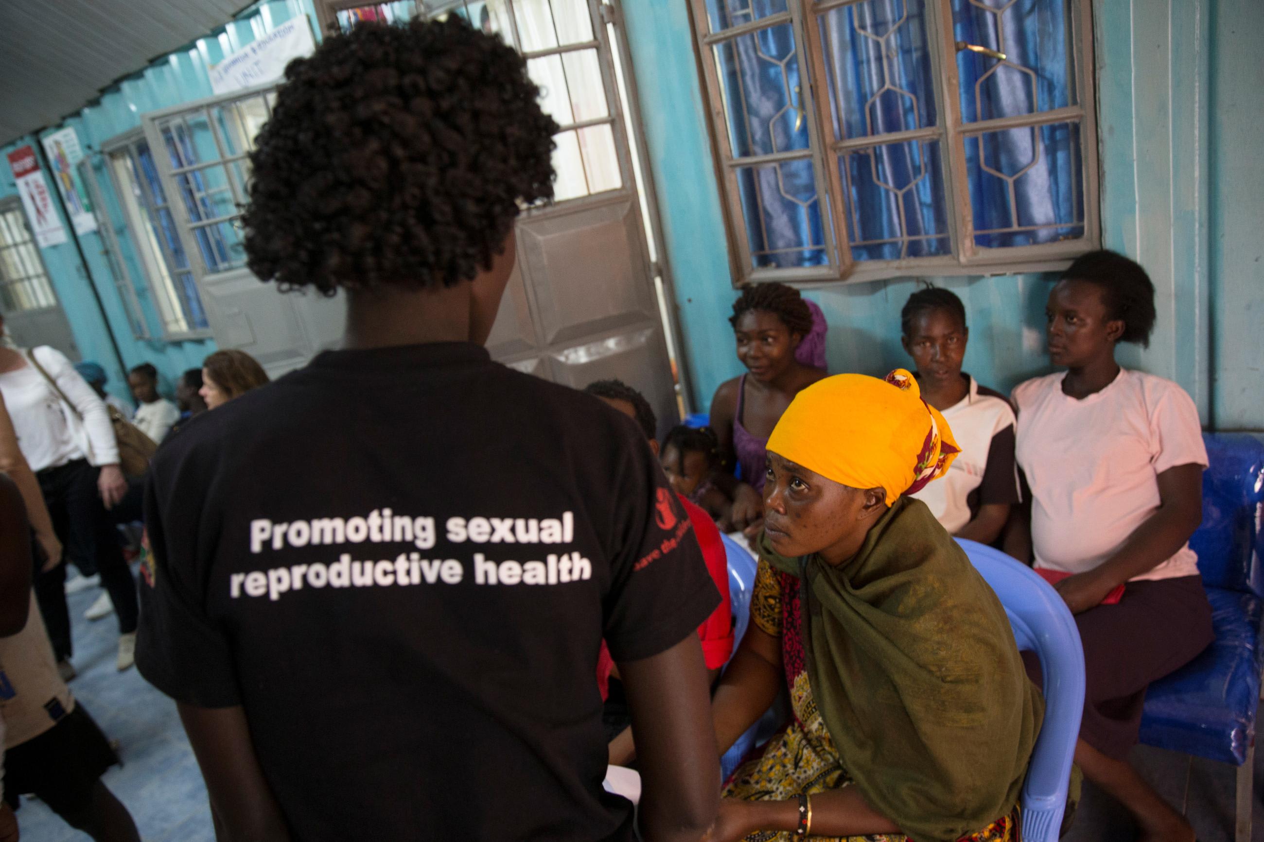 A health worker (L) speaks to patients during at a Family Health Options clinic in the Kibera slums in Nairobi, Kenya, May 16, 2017. picture taken May 16, 2017.