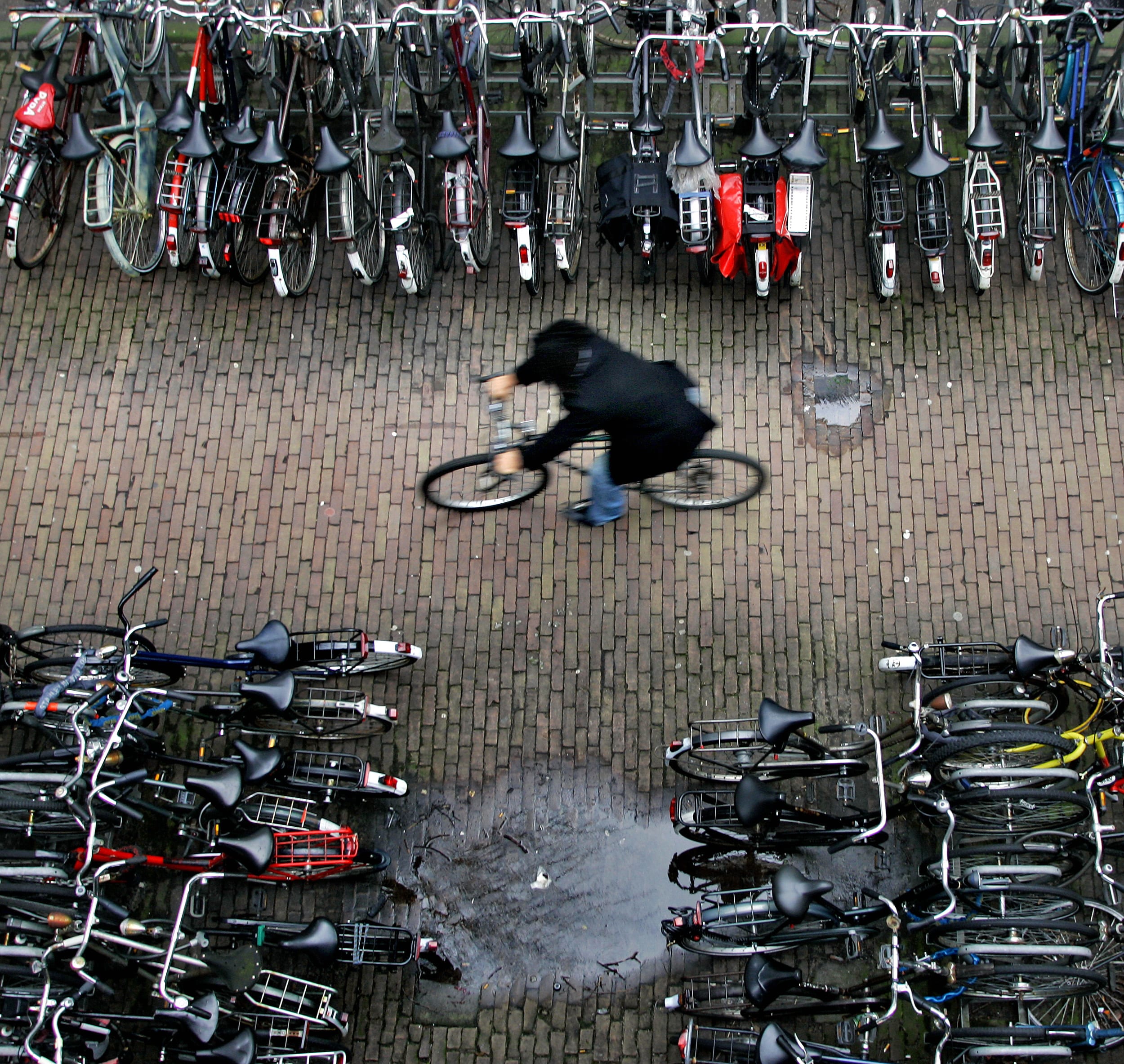 A man rides his bike in a bicycle shed, near Central Station, in Amsterdam, the Netherlands, on January 17, 2007. There are more bicycles than people in the Netherlands.