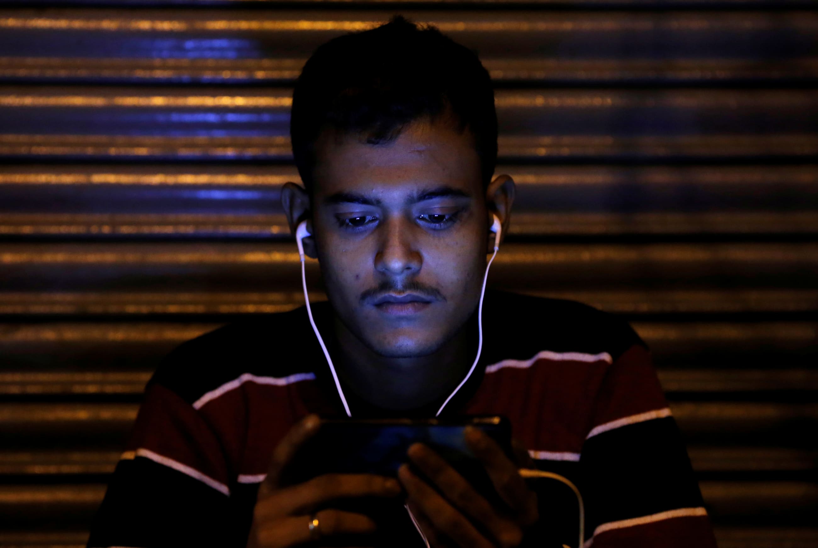 A man watches a movie on his phone, in Delhi, India, on November 16, 2016.