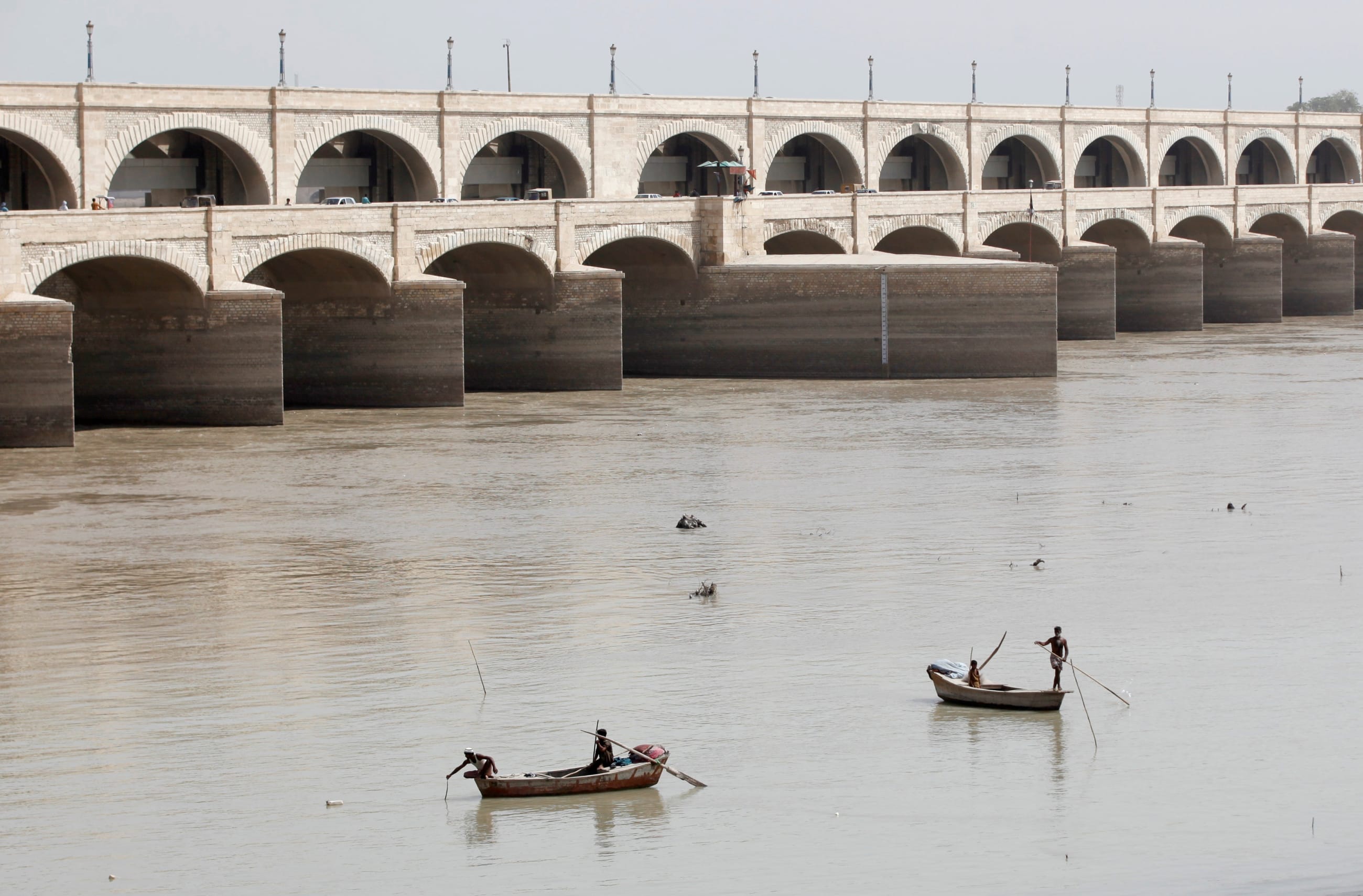 Fishermen row their boats as they catch fish on the Indus River, in Sukkur, Pakistan, on March 19, 2017.