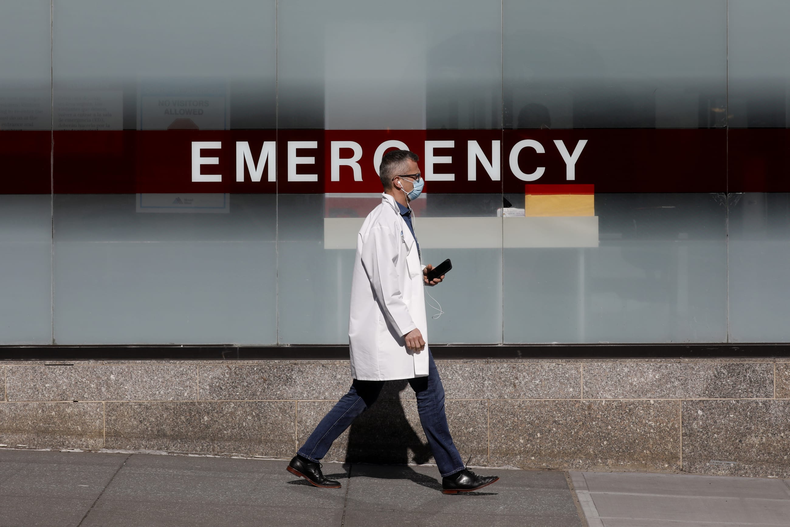 A doctor wears a protective mask as he walks outside Mount Sinai Hospital, in Manhattan, New York City, New York, on April 1, 2020. 
