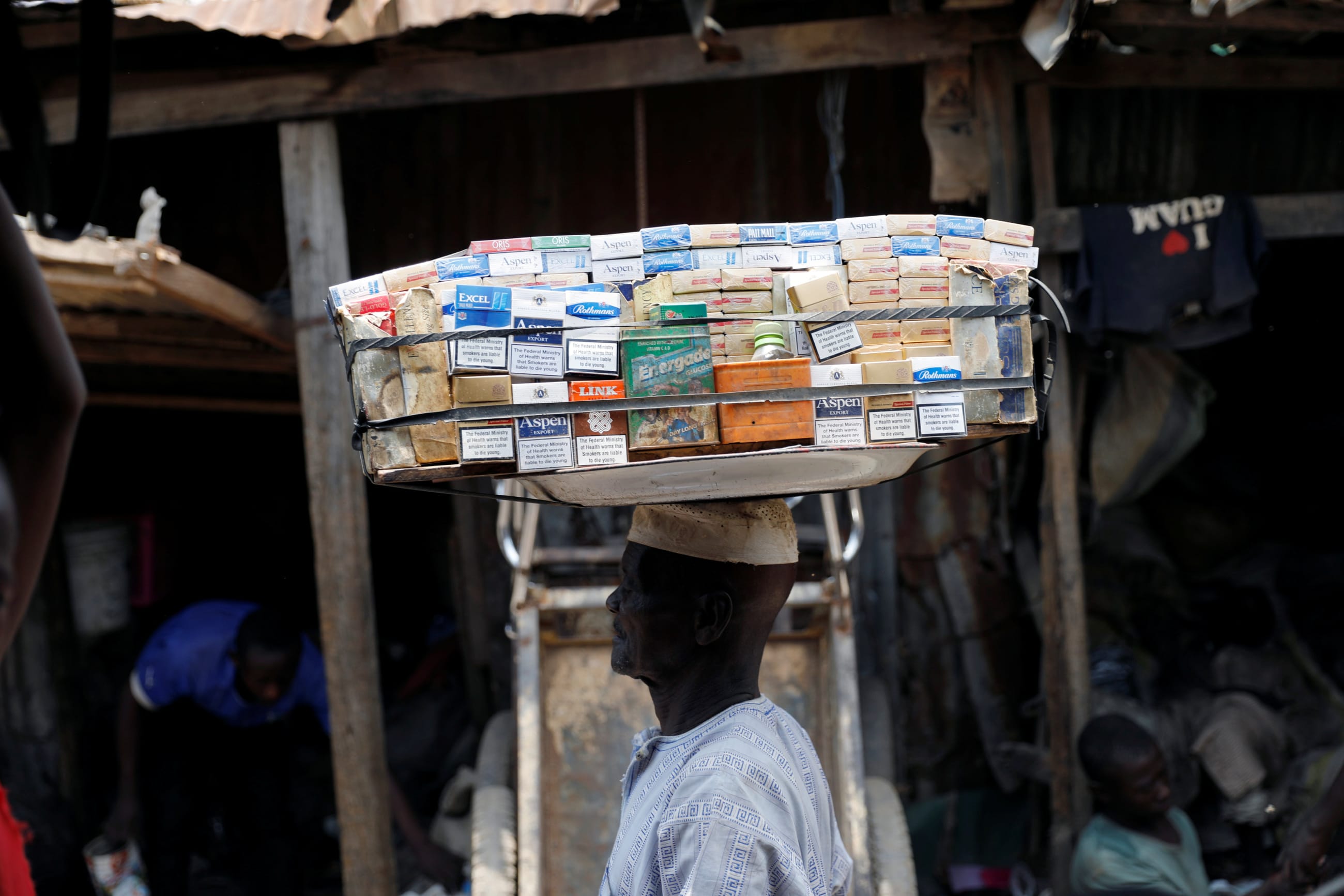 A man selling packets of cigarettes walks through a street, in the old district of Kano, Nigeria, on August 24, 2017.