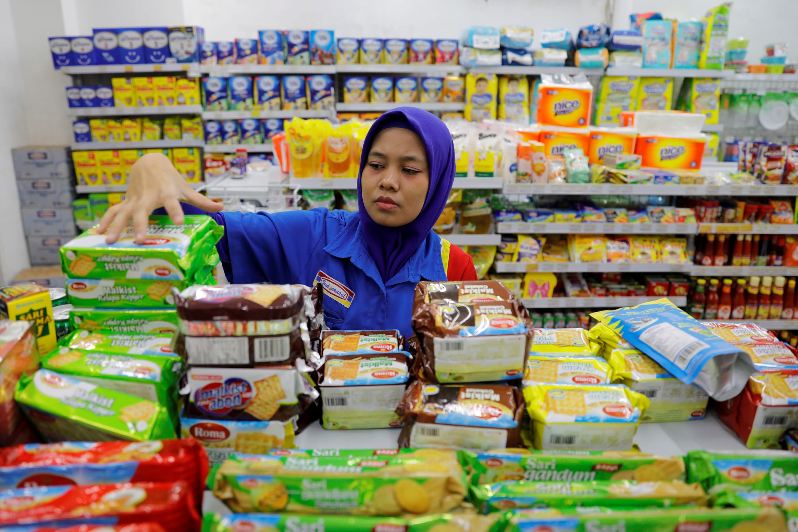 A shopkeeper arranges snacks to sell at a mini market, in Jakarta, Indonesia, on February 15, 2019.