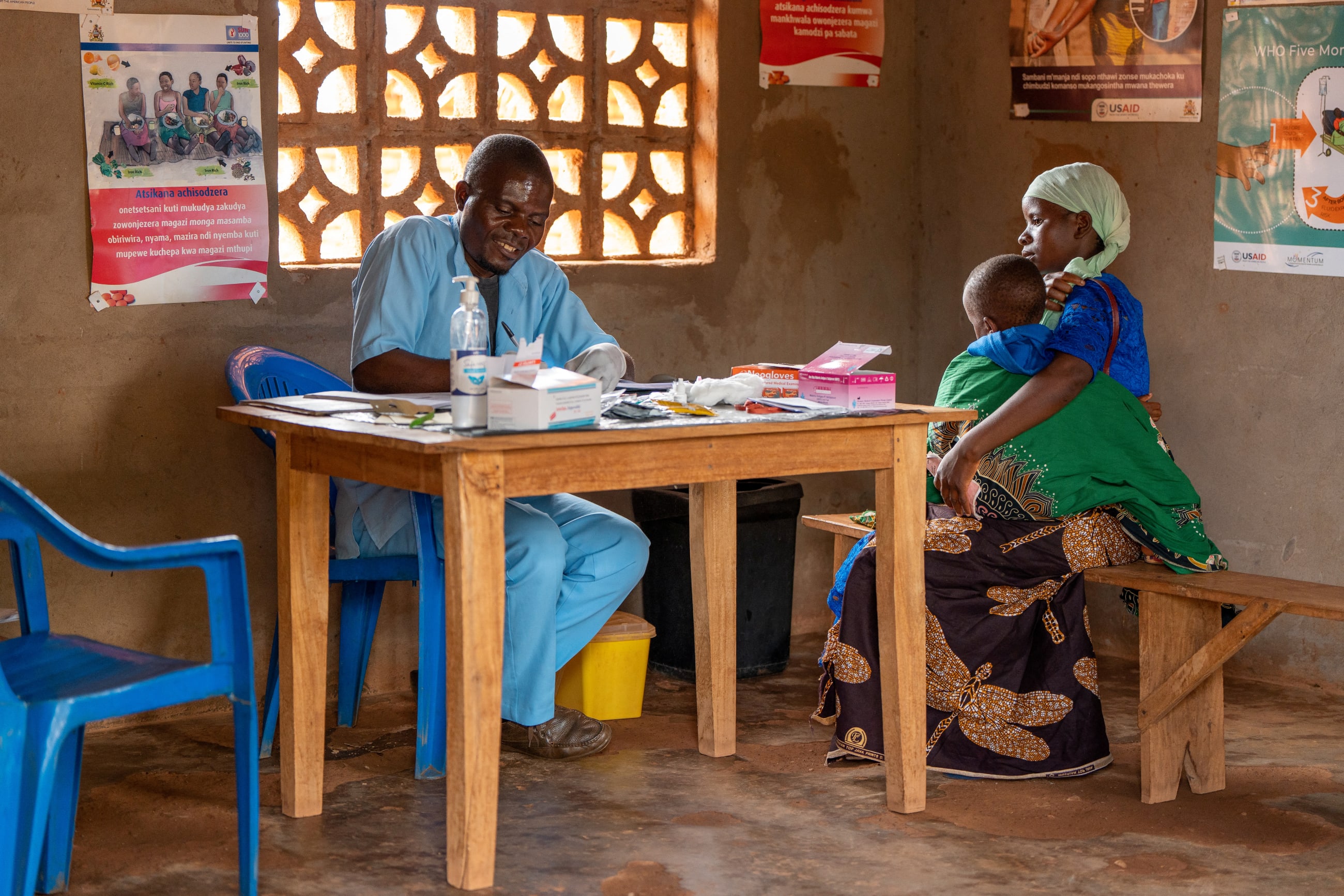 A health worker writes in a register details of the child after testing for malaria, at Chipili Community Center, in Lilongwe, Malawi.