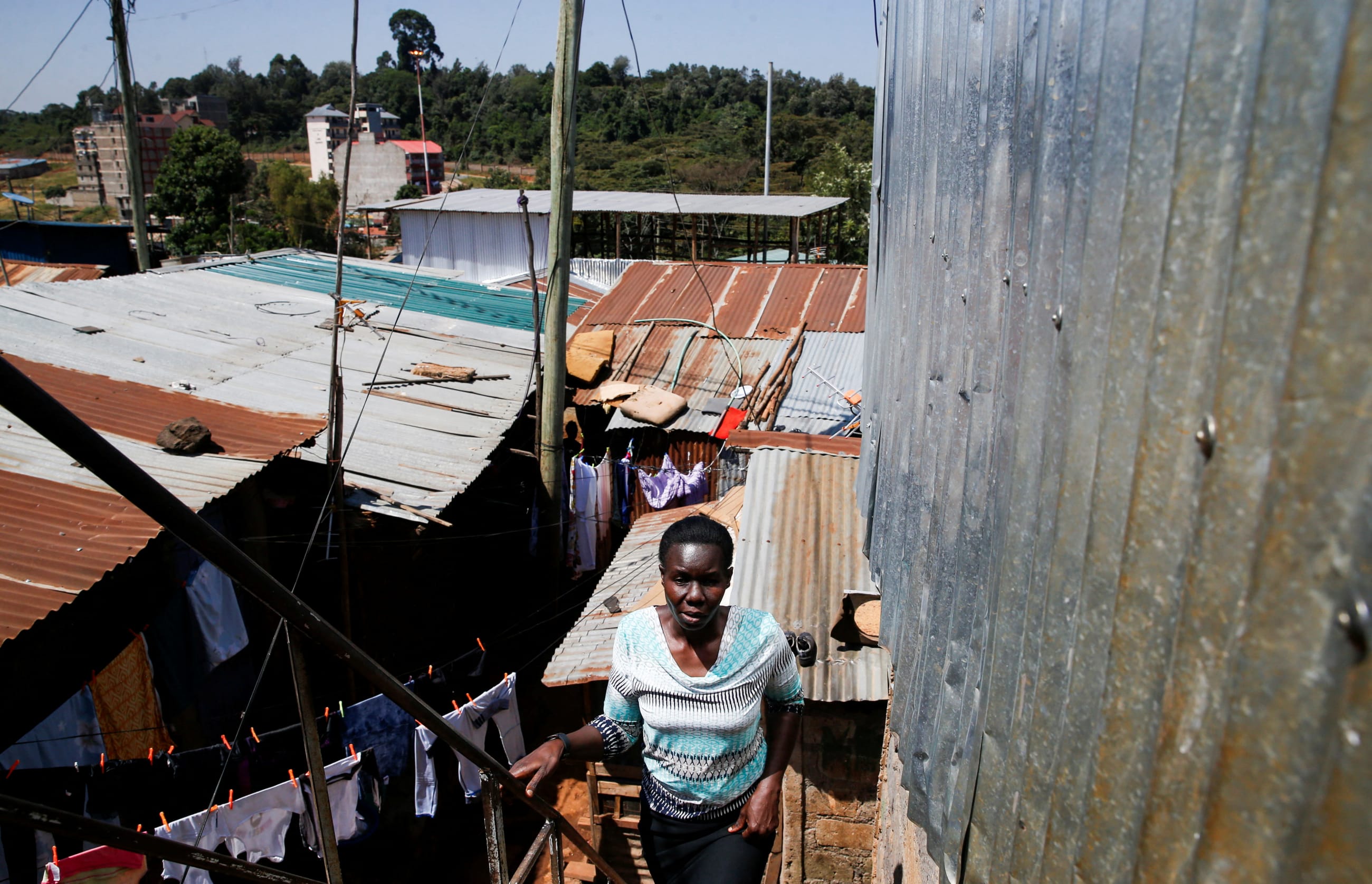 Alice Okwirry, a widow living with HIV/AIDS, walks outside her house, in Nairobi, Kenya, on February 28, 2025.