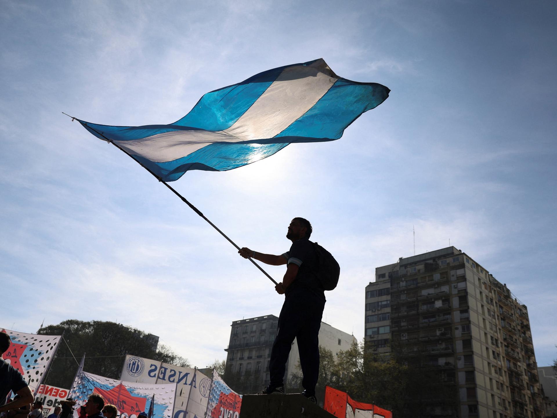 A demonstrator waves the Argentinian flag while taking part in a march to defend public universities, after Argentina's President Javier Milei vetoed laws to boost funding for pediatric hospitals and public universities, citing efforts to rein in public spending, in Buenos Aires, Argentina, on September 17, 2025. 
