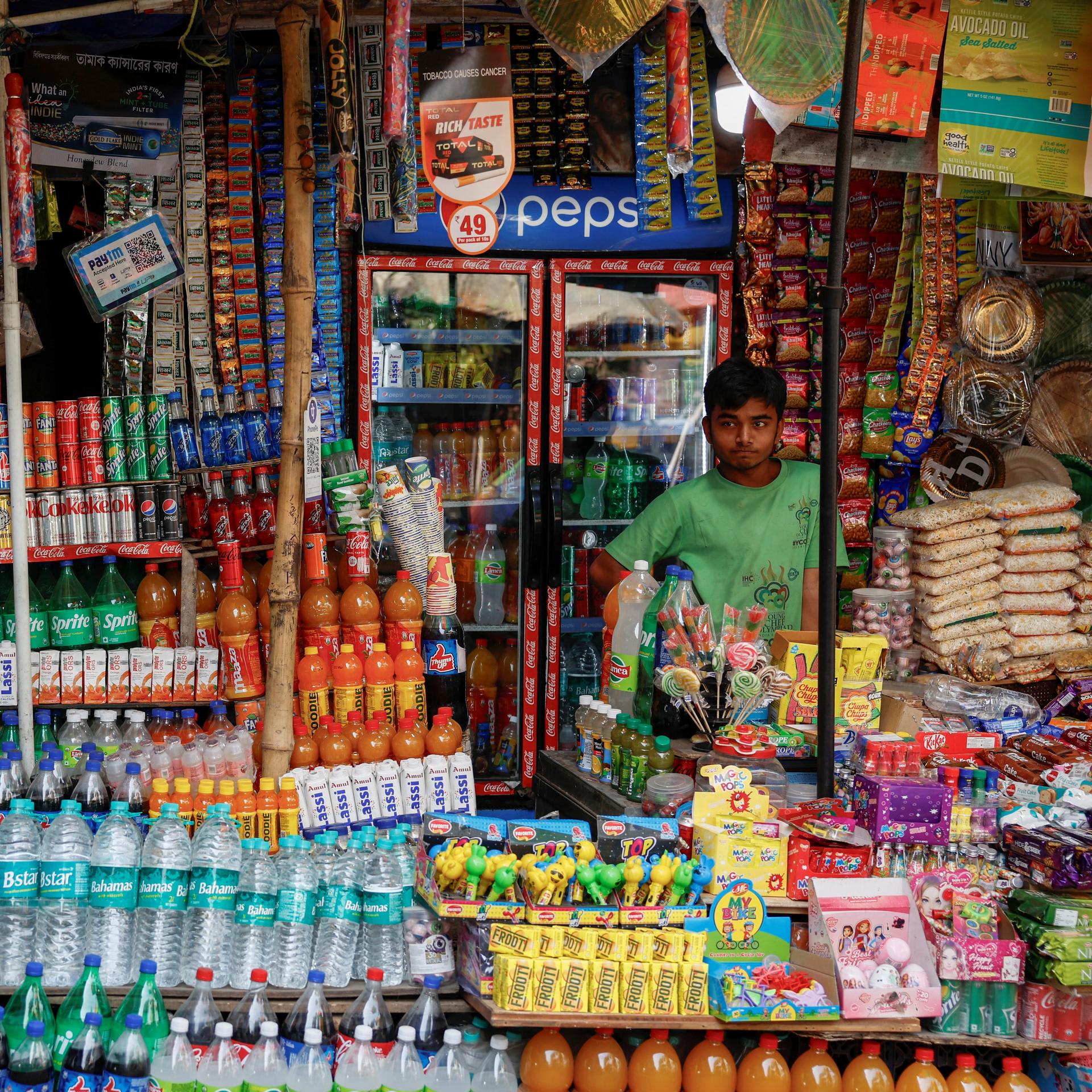 A vendor selling snacks and refreshment drinks waits for customers, outside Alipore Zoological Garden, in Kolkata, India, on May 1, 2024