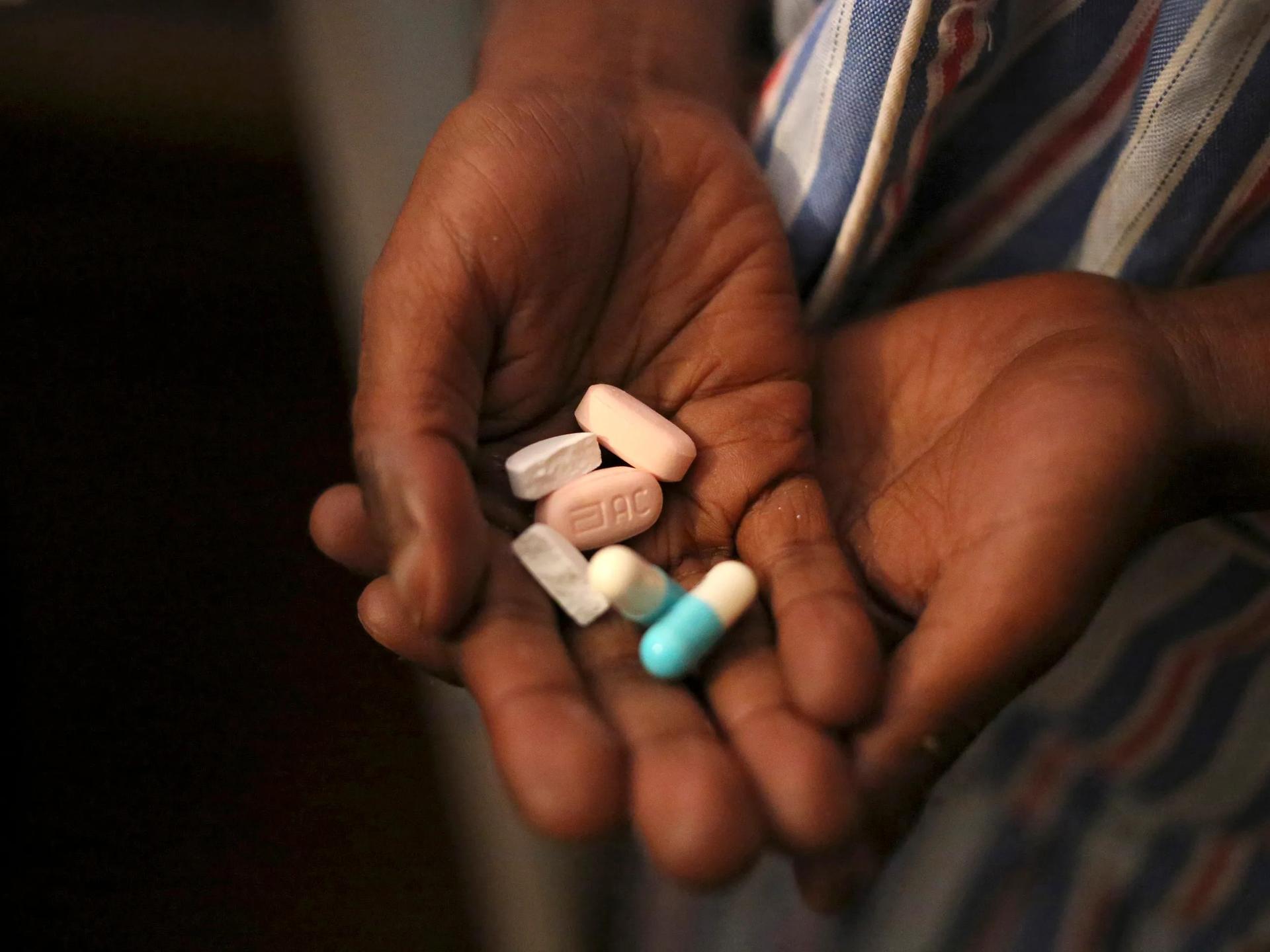 A boy holds a handful of antiretroviral pills before taking his medication at Nkosi's Haven, in Johannesburg, South Africa, on November 28, 2014.