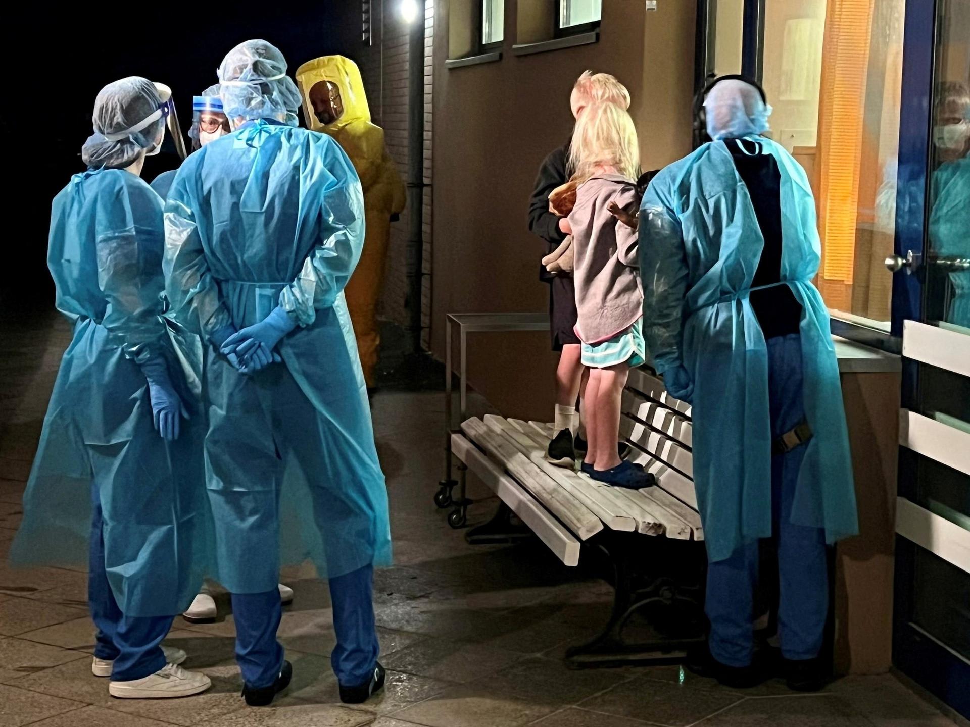 Two children of an American Ebola patient look through a window at their father in the isolation ward, at the Charite hospital, in Berlin, Germany, on May 21, 2026.   