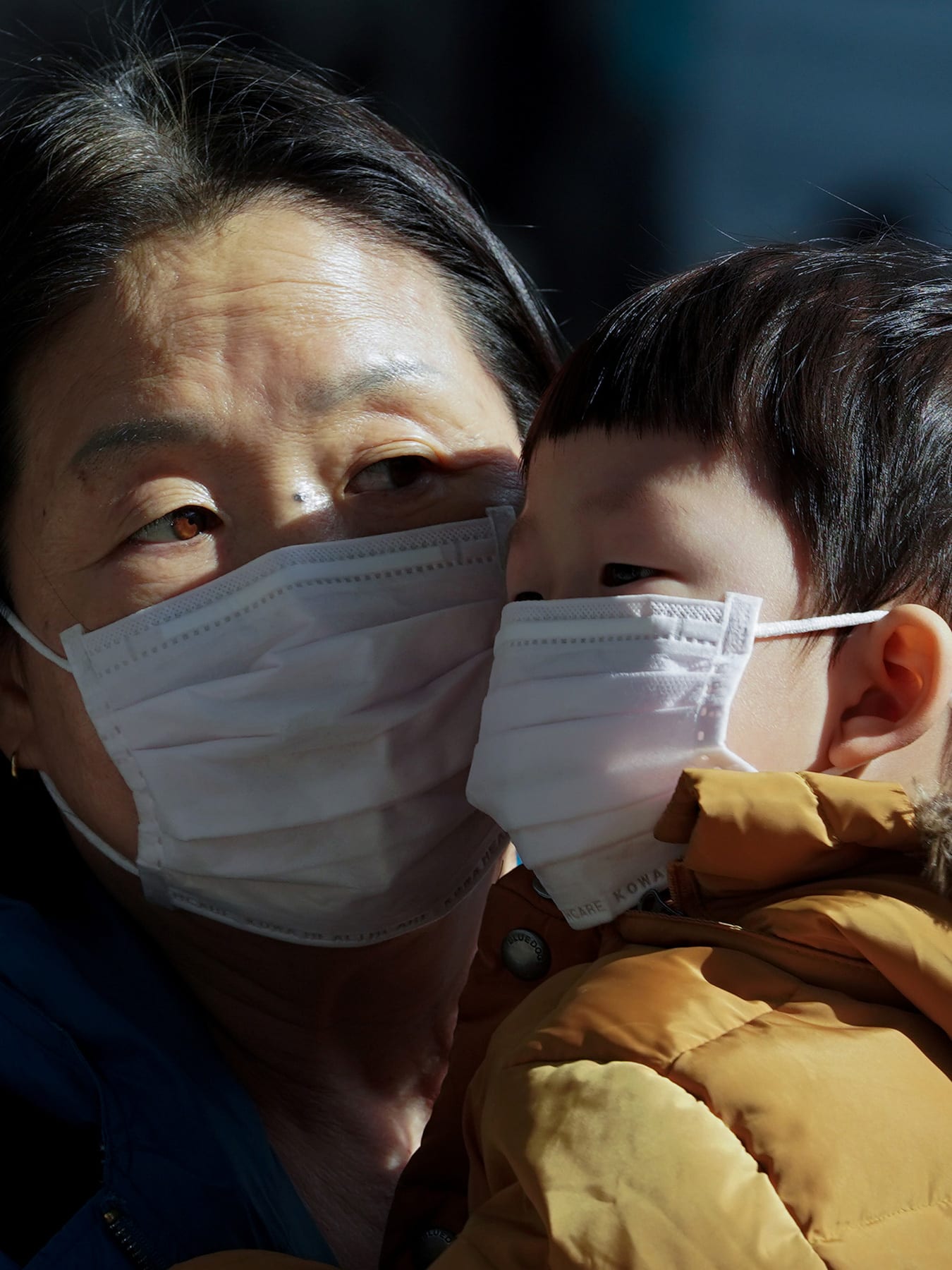 The photo shows the two face to face with each other, but their faces are covered almost completely below their eyes by the dust masks.