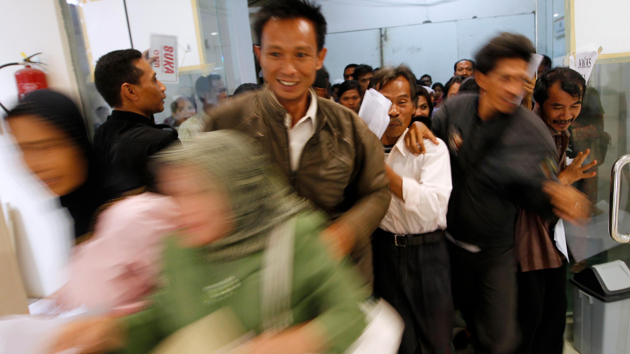 Photo shows many people jostling at the entrance of the hospital.