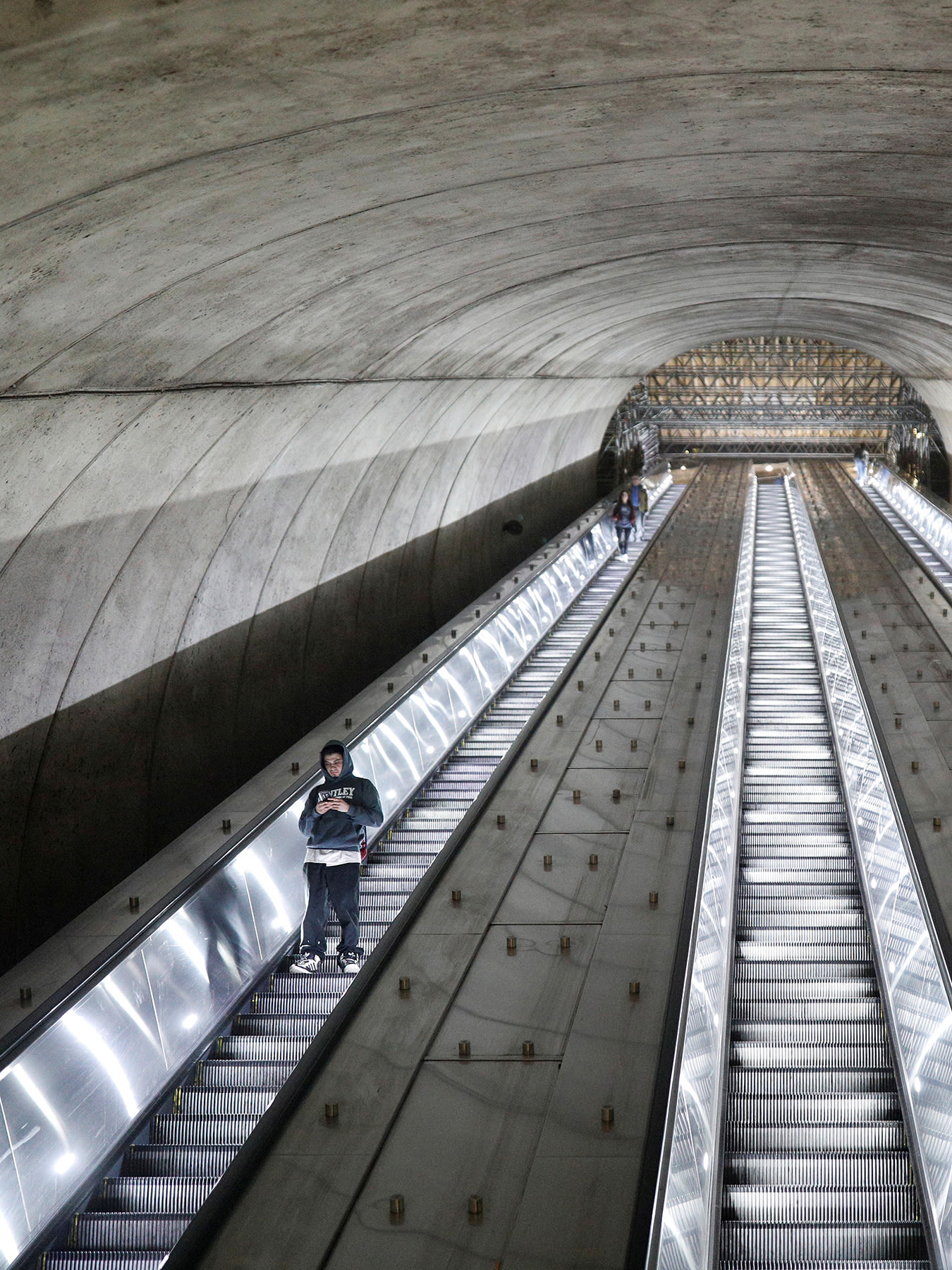 The picture shows a long escalator tube almost empty.