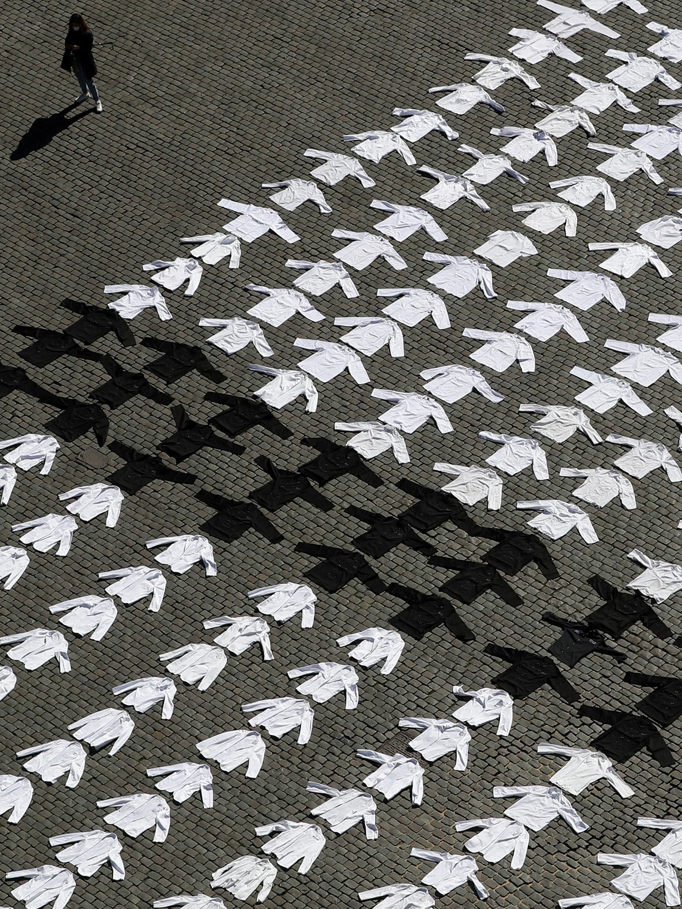 The photo shows an array of shirts, mostly white but a few black ones, laid out over thousands of square feet of a lawn. It's a striking photo.