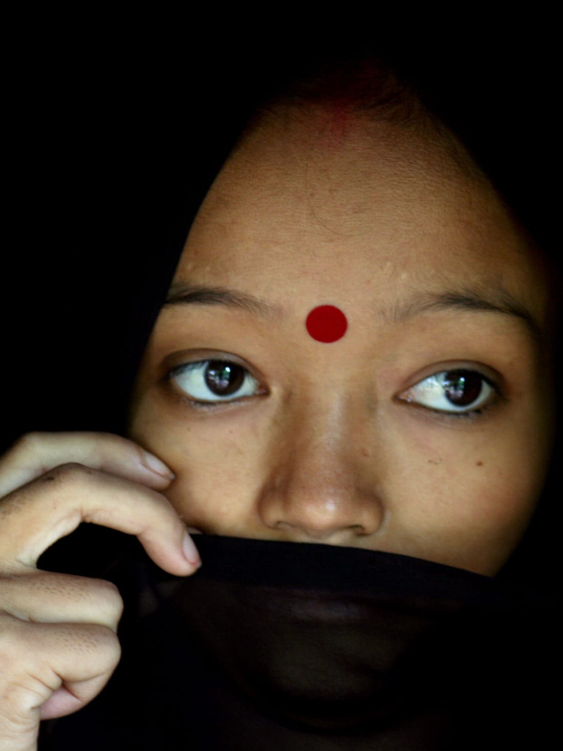 The photo shows the woman with a wrap covering her mouth.
