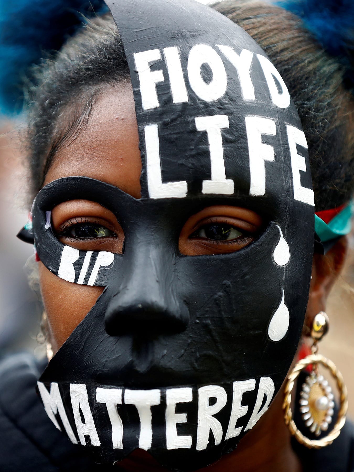 The picture shows a woman in a striking mask adorned with the words Floyd's Life "Mattered."