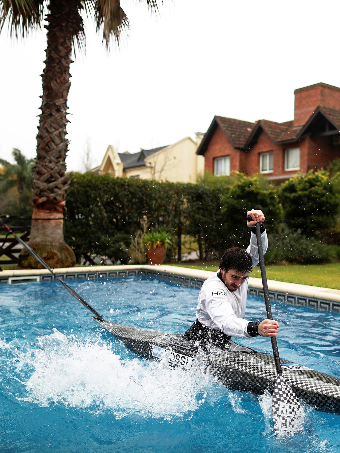The photo shows the canoeist rowing furiously in a swimming pool.