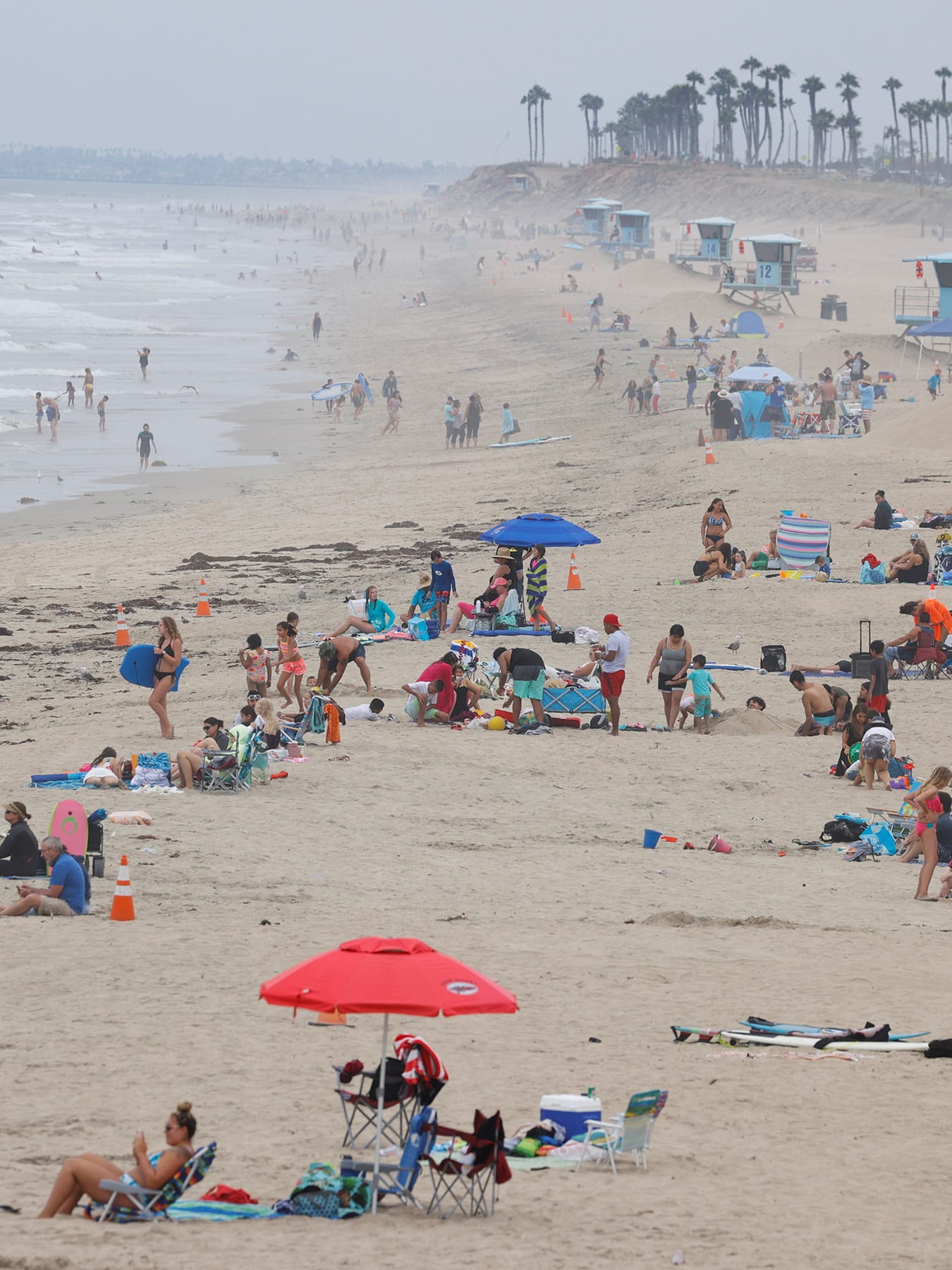 The photo shows a beach crowded with people. 