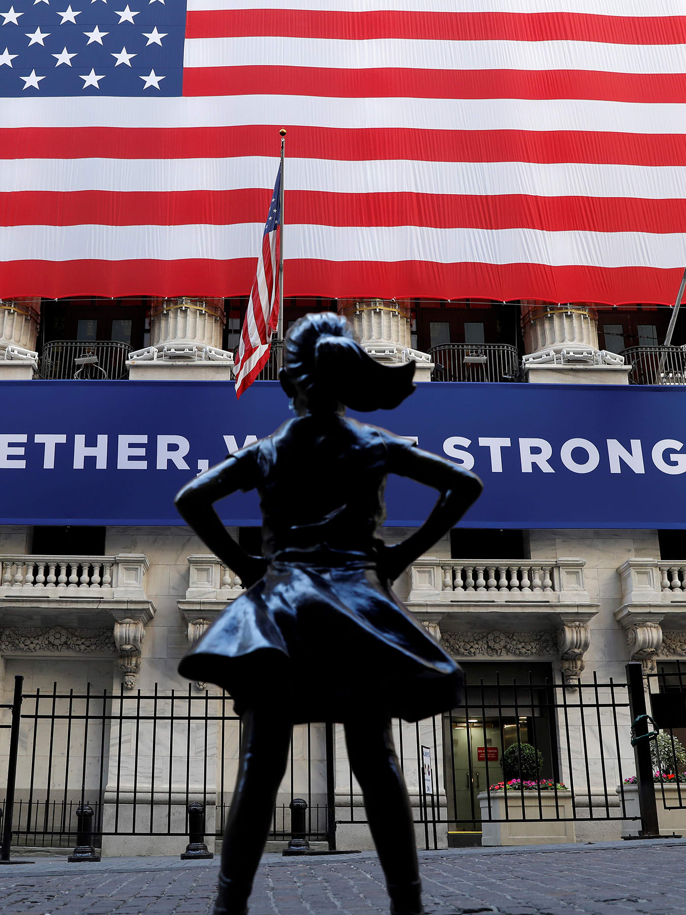 The photo shows the statue with a huge American flag in the background.