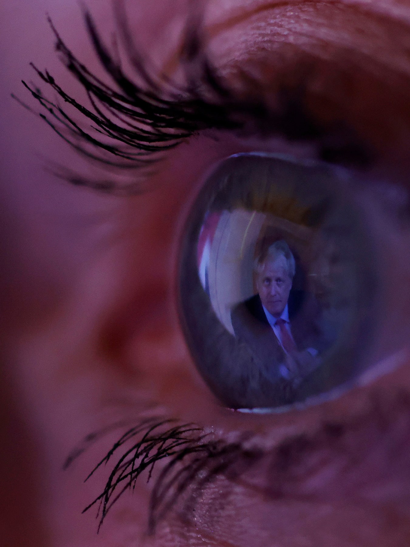 The photo shows a macro lens image of an eye with the image of the PM reflected in it.