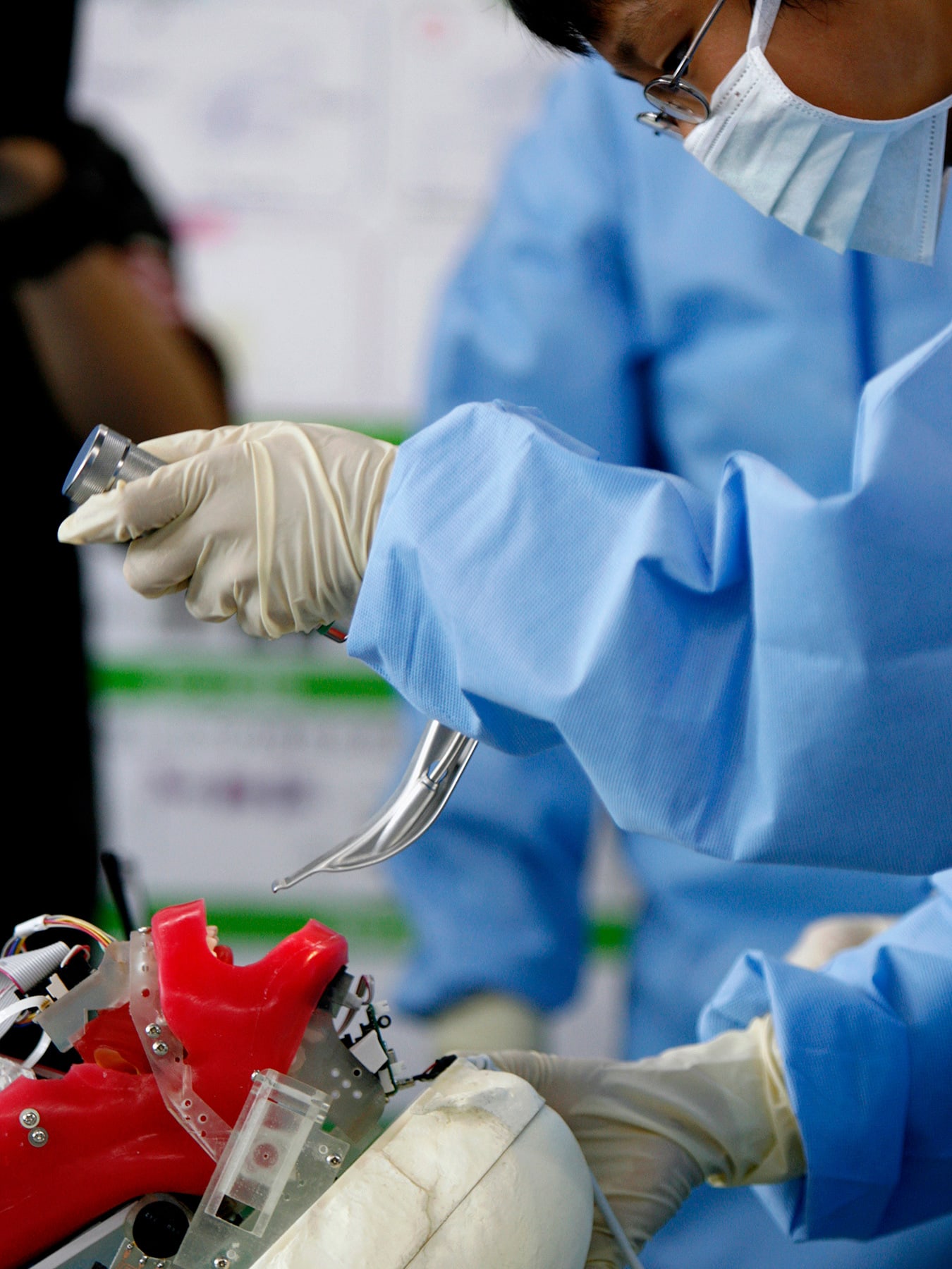 The photo shows a person inserting a tracheal tube into a robot mannekin.