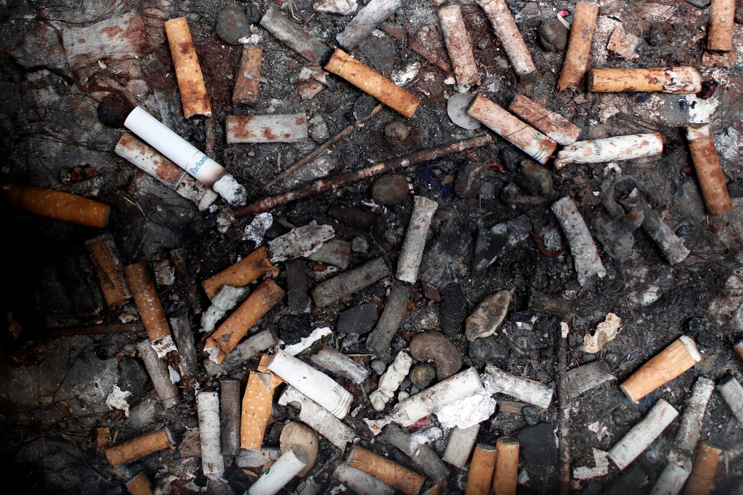 Discarded cigarette butts are seen beneath a sidewalk grating in Manhattan in New York City, May 8, 2017.