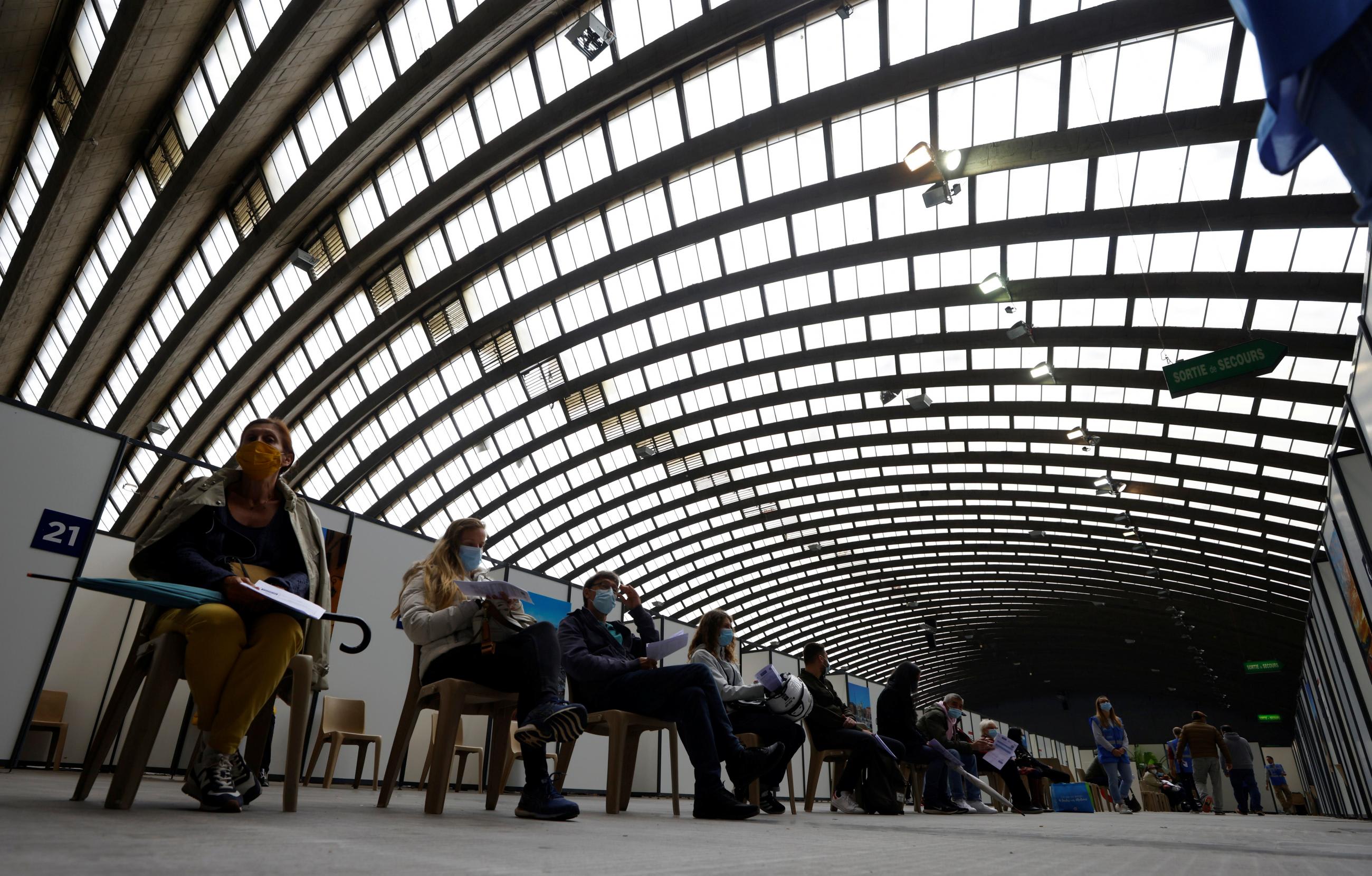 People wait in a vaccination center installed inside the exhibition palace in Nice as part of the coronavirus disease vaccination campaign in France, on April 29, 2021.